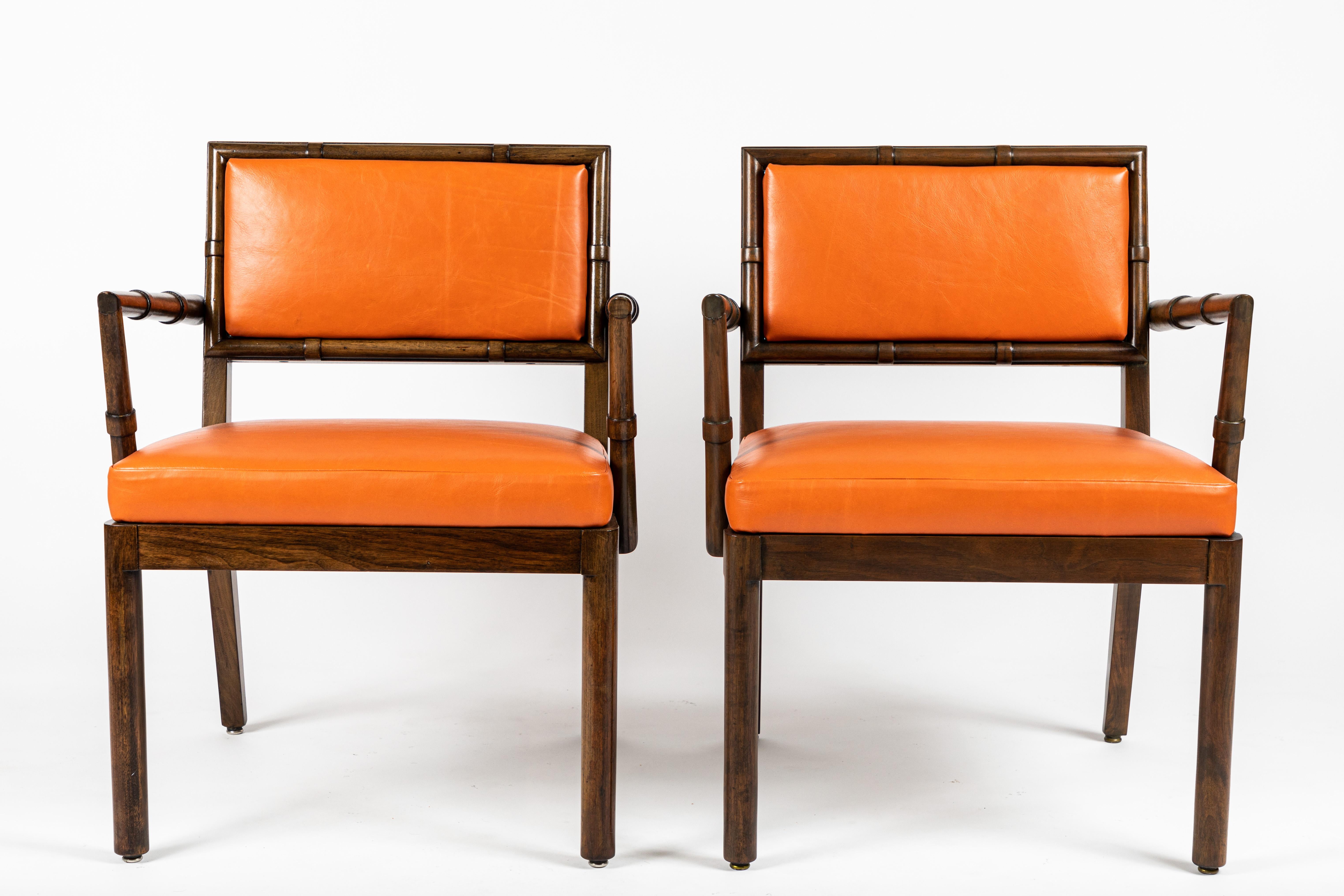 A Classic design, these armchairs we used on quite a few Haines commissions. The arms and back feature a stylized bamboo motif. The upholstered seats are newly redone in an orange leather. There are slight variations in the two chairs most notably