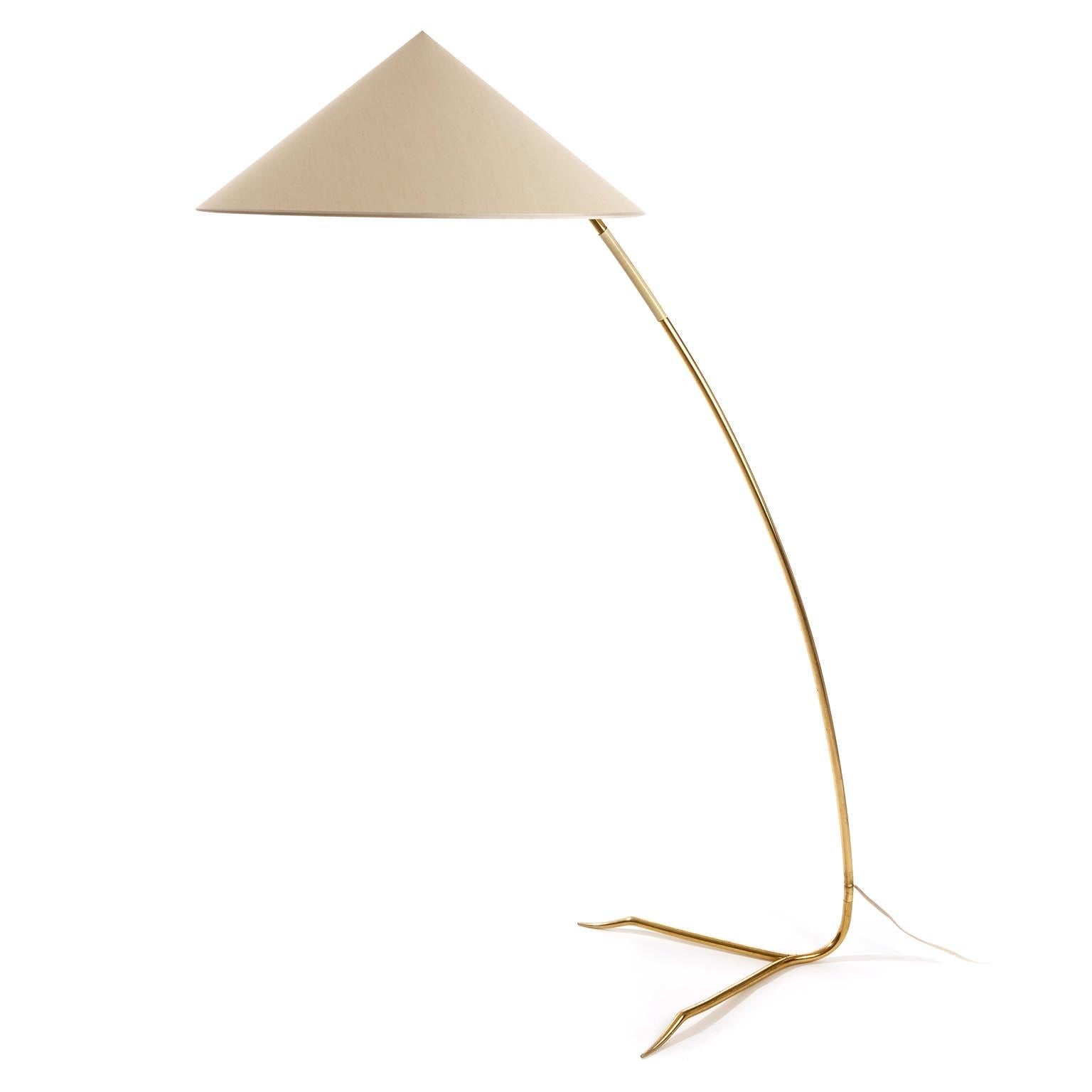 One of two gorgeous and rare floor lights with model name 'Sumatra' by Rupert Nikoll, Austria, manufactured in midcentury, circa 1950s.
A cone shaped lamp shade sits on a solid brass stand with a white plastic handle and a straddled base.
The