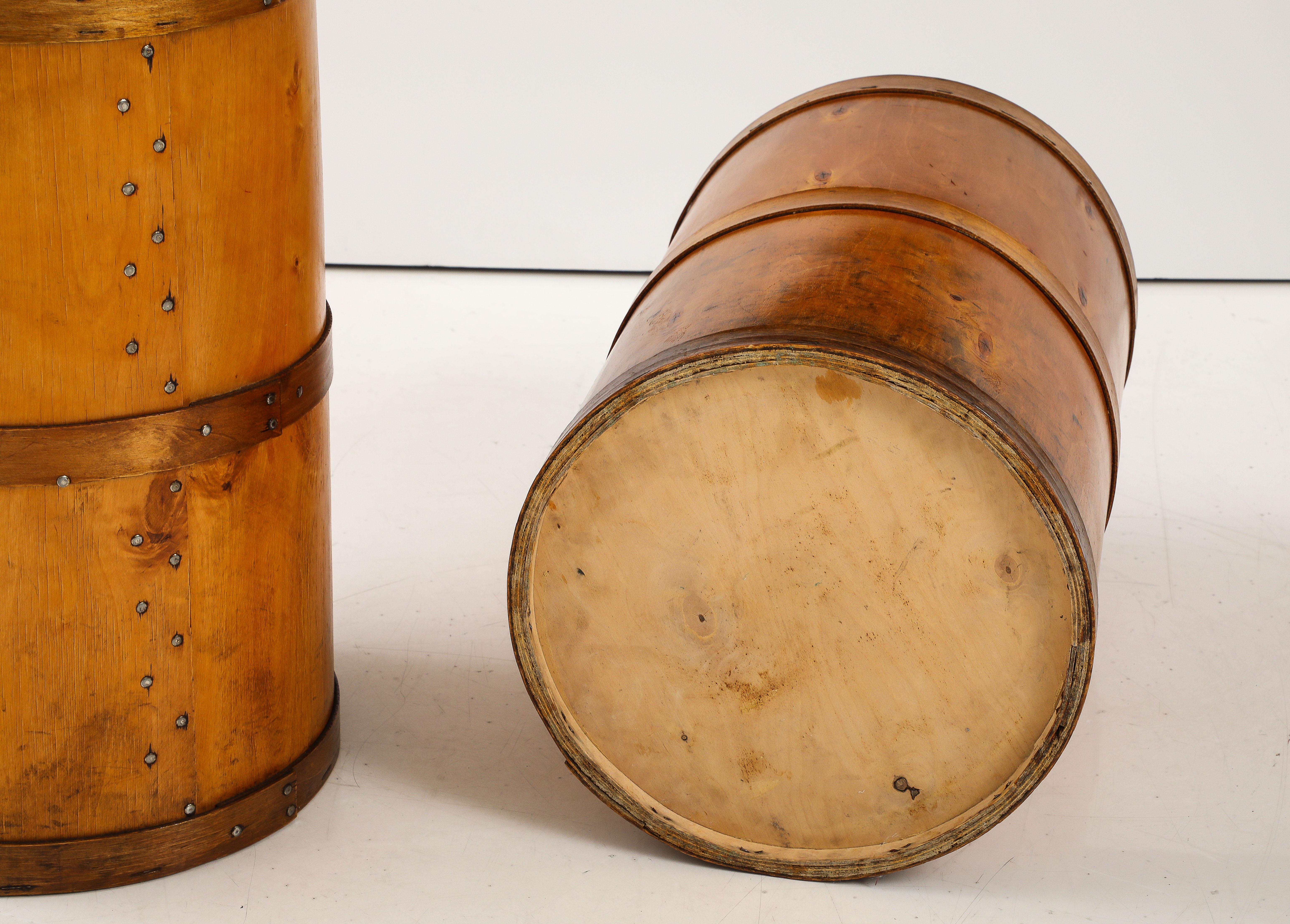 Two Swedish birch storage barrels, Circa 1960s, of typical barrel form with removable lids held in place with brass and metal brackets. These barrels were apparently used for sugar shipping and storage. They have stamps of Malmö port, Sweden. They