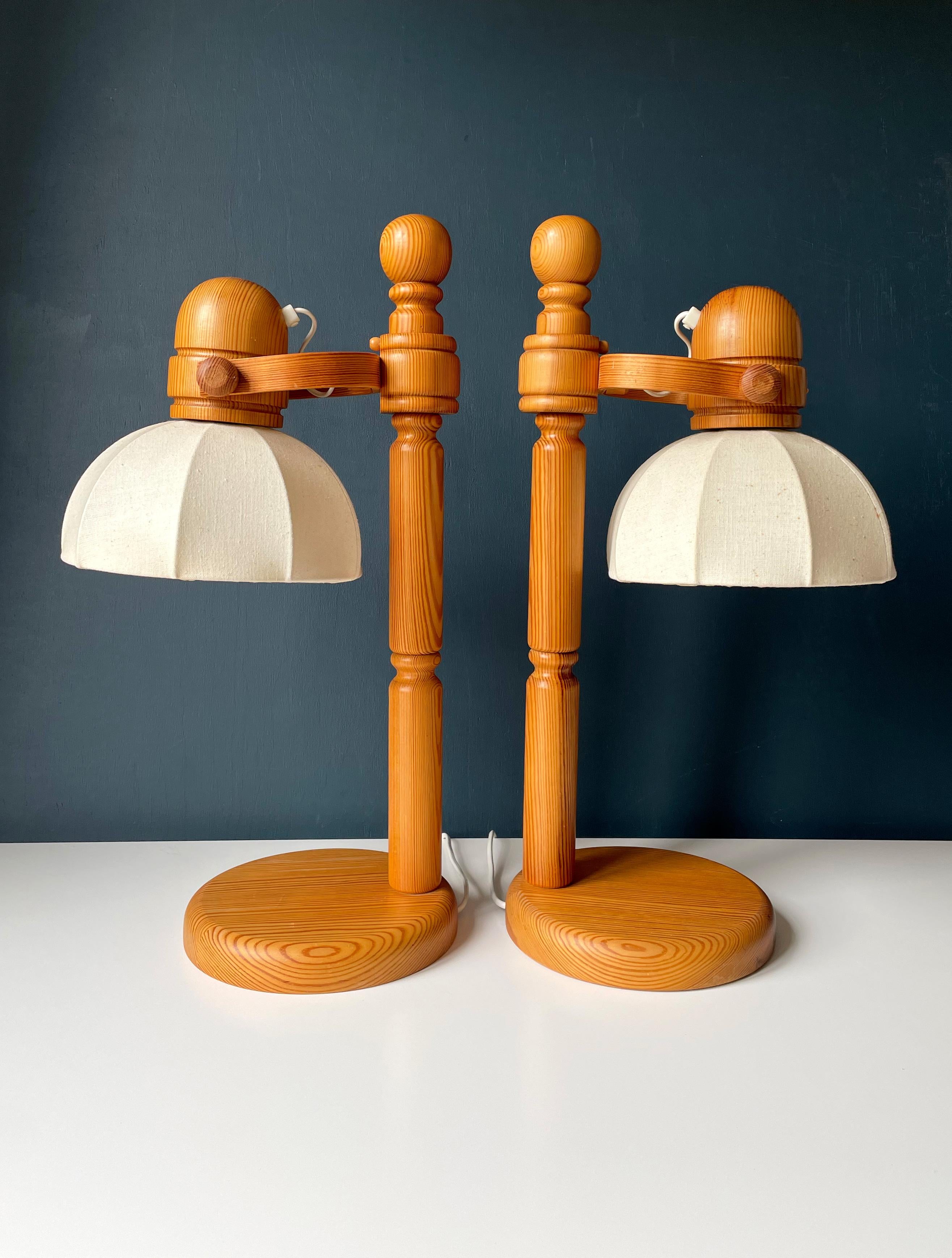 Pair of large Swedish Mid-Century Modern lacquered solid pine wood table lamps manufactured by Markslöjd in the 1960s. Turned soft rounded shapes and bentwood on the adjustable shade mount. Original cream white linen shade. E27 bulb max 60W. Label
