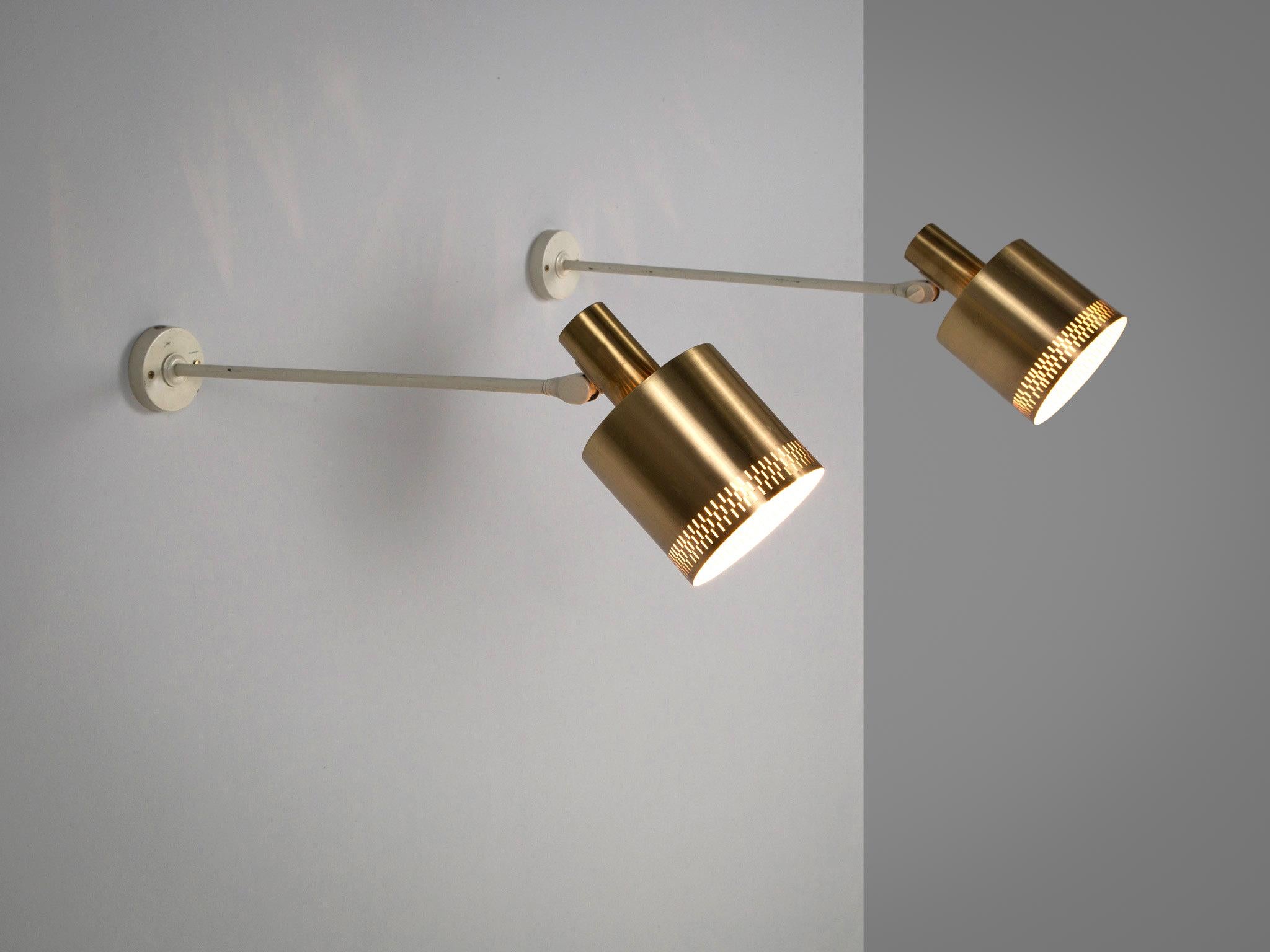 Pair of wall lights, brass and metal, Sweden, 1970s.

Set of two Swedish white metal wall lamps with brass shades. The shades are adjustable so both the wall and the room can be illuminated. The brass shade has perforated details which provide a