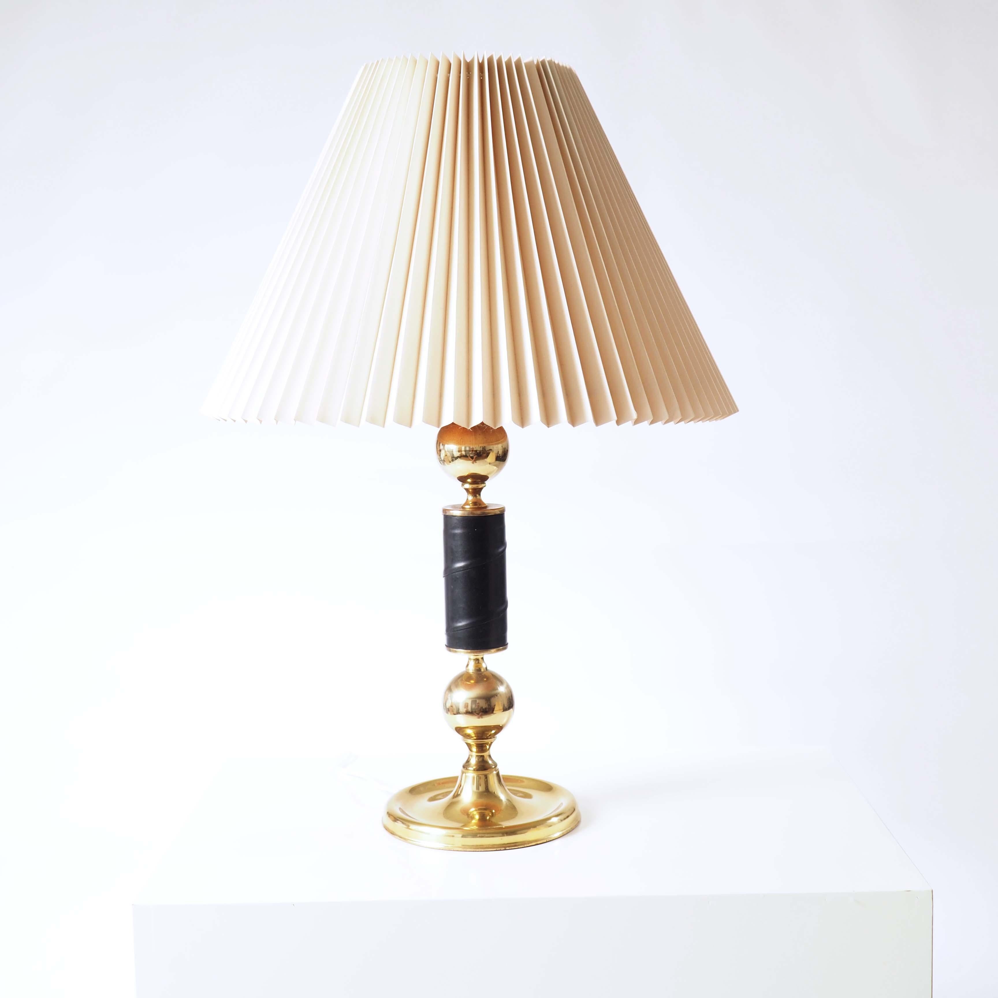 Deux lampes de table en laiton avec des détails en cuir. Les teintes pliées sont incluses. Les lampes sont de haute qualité, lourdes et solides et ont été fabriquées au début des années 1960.