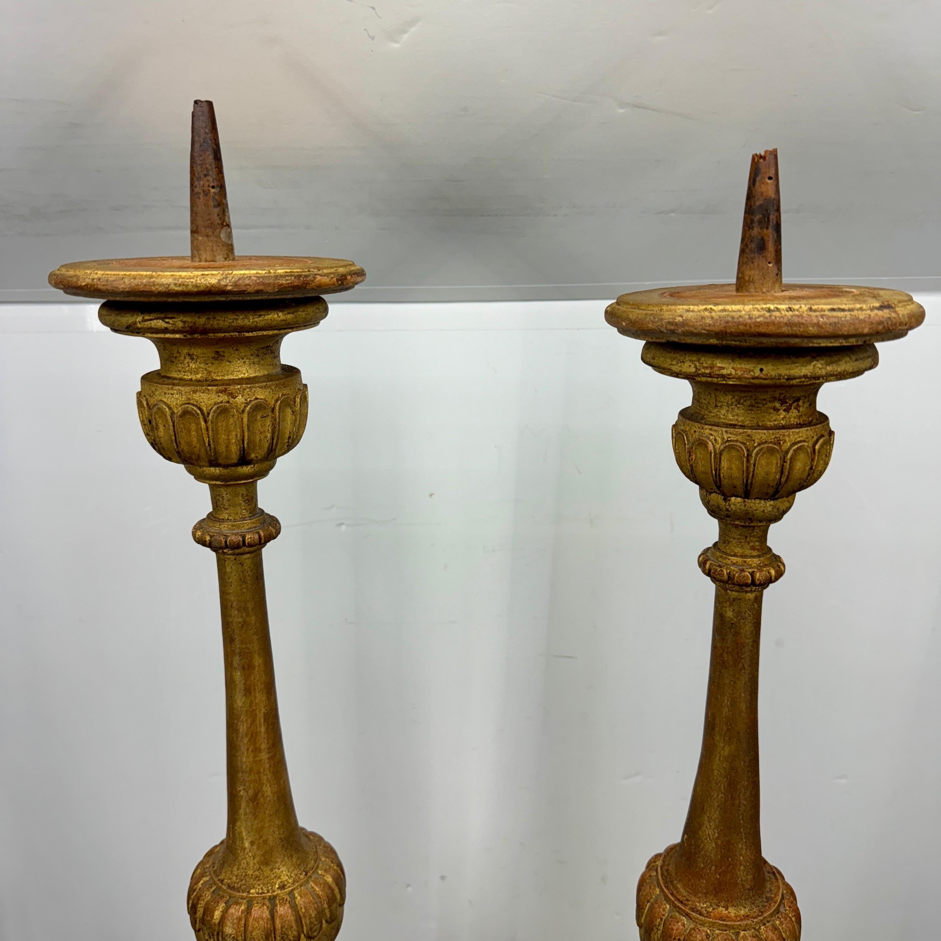 Set of two carved gold gilded alter candlesticks with original patina and prickets. These large untouched church pricket candlesticks are carved from wood and have iron spikes for displaying candles. Wonderful addition as a centerpiece on a long