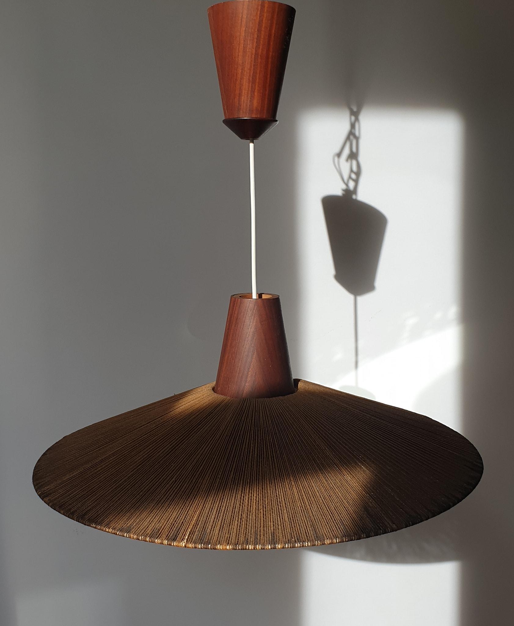 A wonderful pair of Scandinavian teak hanging lamp made in the 1950s-1960s. It is fascinating with its rare cone lamp shade. The rope of the lamp is also height adjustable. The height is min 53 cm and max 167cm.