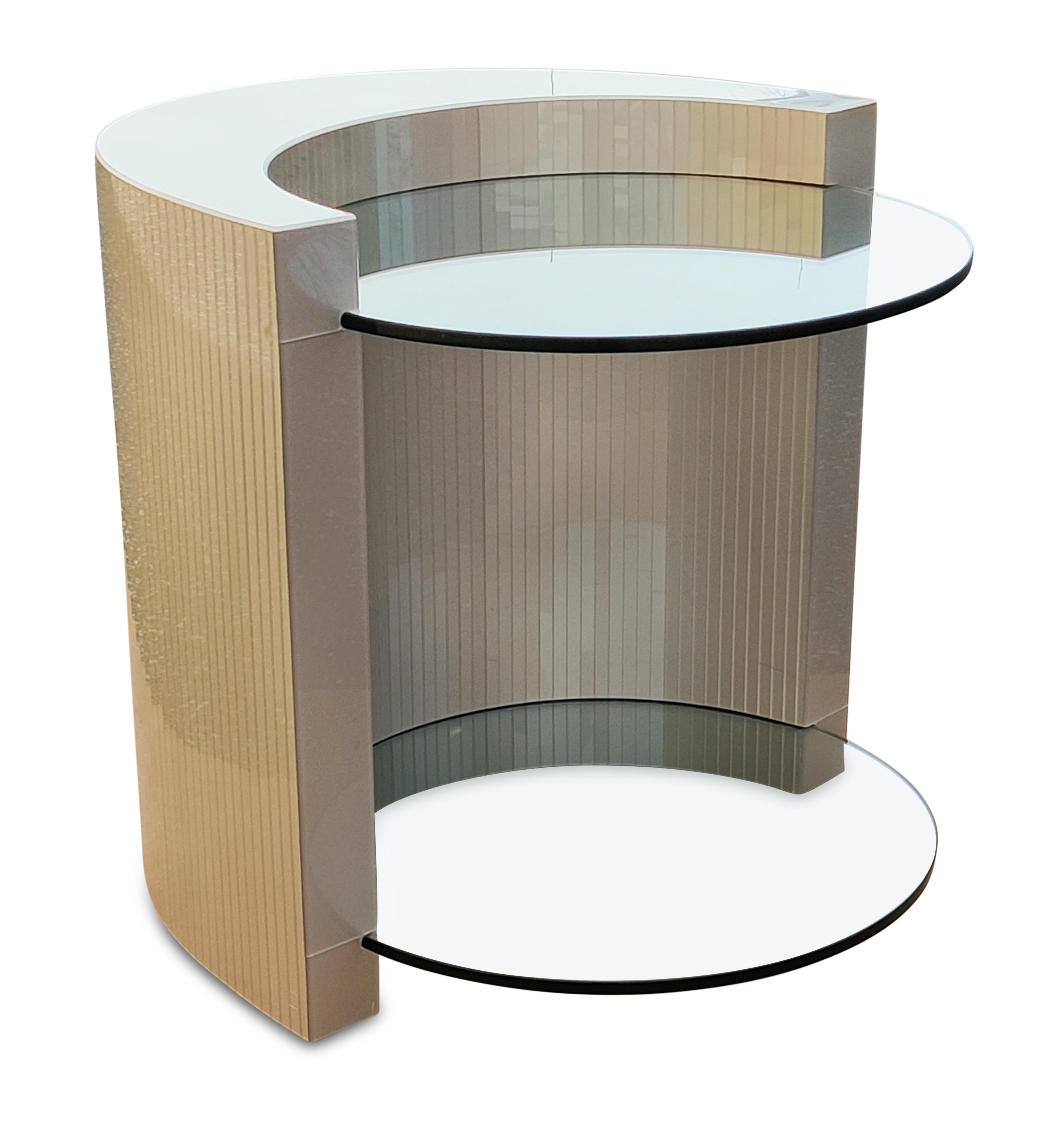 This beautiful side table has unique construction. Shaped like a crescent, it has a curved wood frame overlaid with elegant gray lucite strips. About 3 inches below the top of the crescent and 3 inches above the bottom, there are slots in the base