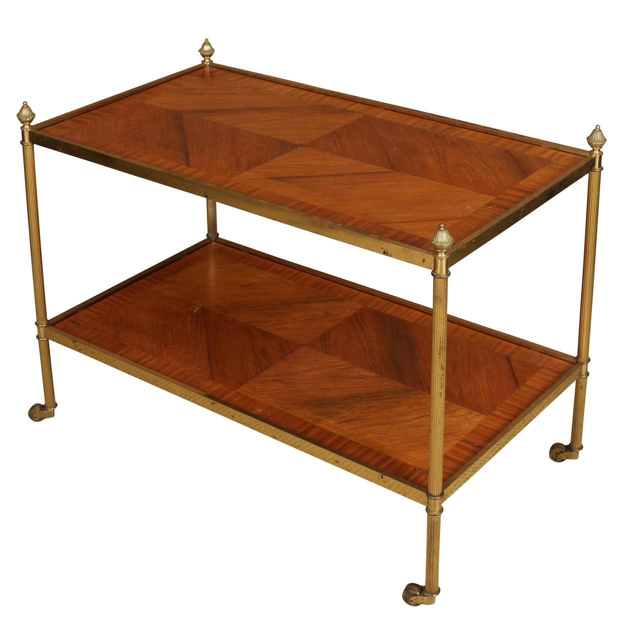 Un carrello a due livelli con una struttura in metallo che dona una calda lucentezza ispirata all'ottone antico. Ognuno dei due ripiani rettangolari è incastonato con pannelli di legno, disposti in modo intricato in un motivo di intarsio a forma di