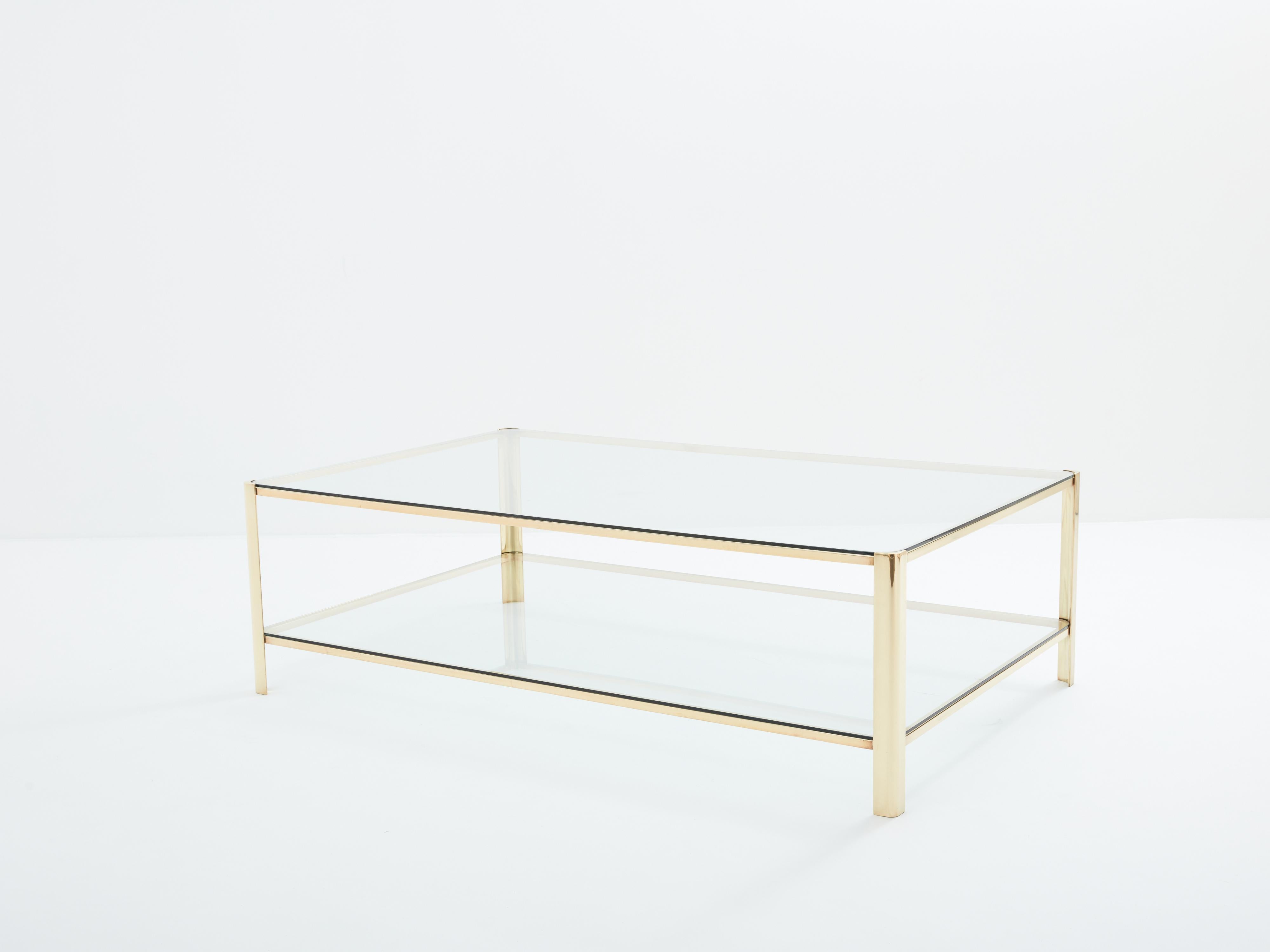 This beautiful coffee table was designed by Jacques Quinet and produced by Broncz in France in the 1960s. The table features a strong, solid polished bronze structure. The original two-tier transparent glass tops add a nice aesthetic appeal as well