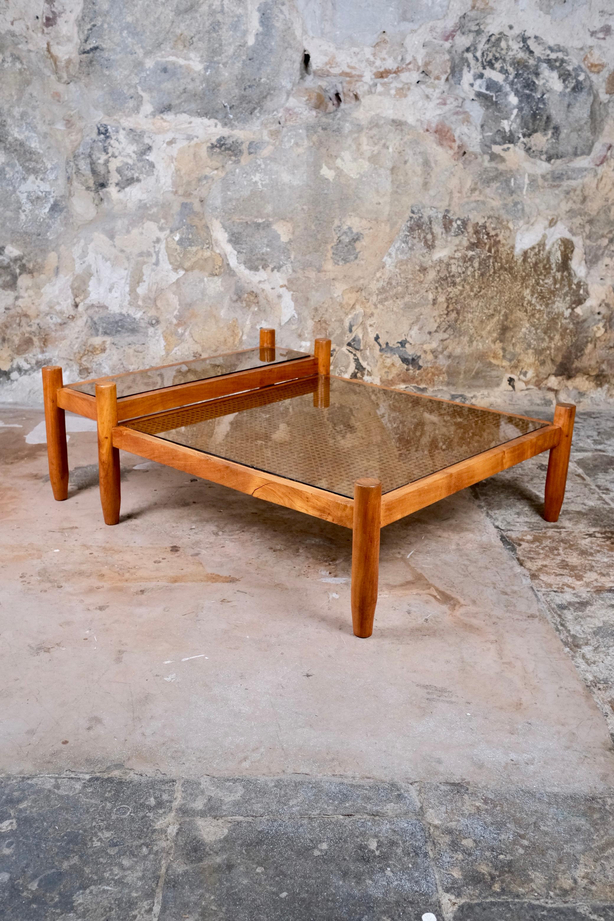 Expression raffinée de l'artisanat français des années 1980, cette table basse à deux niveaux fabriquée sur mesure offre un mélange harmonieux de matériaux naturels et de design réfléchi. Le cadre, sculpté dans un bois de tamarin au grain riche, est