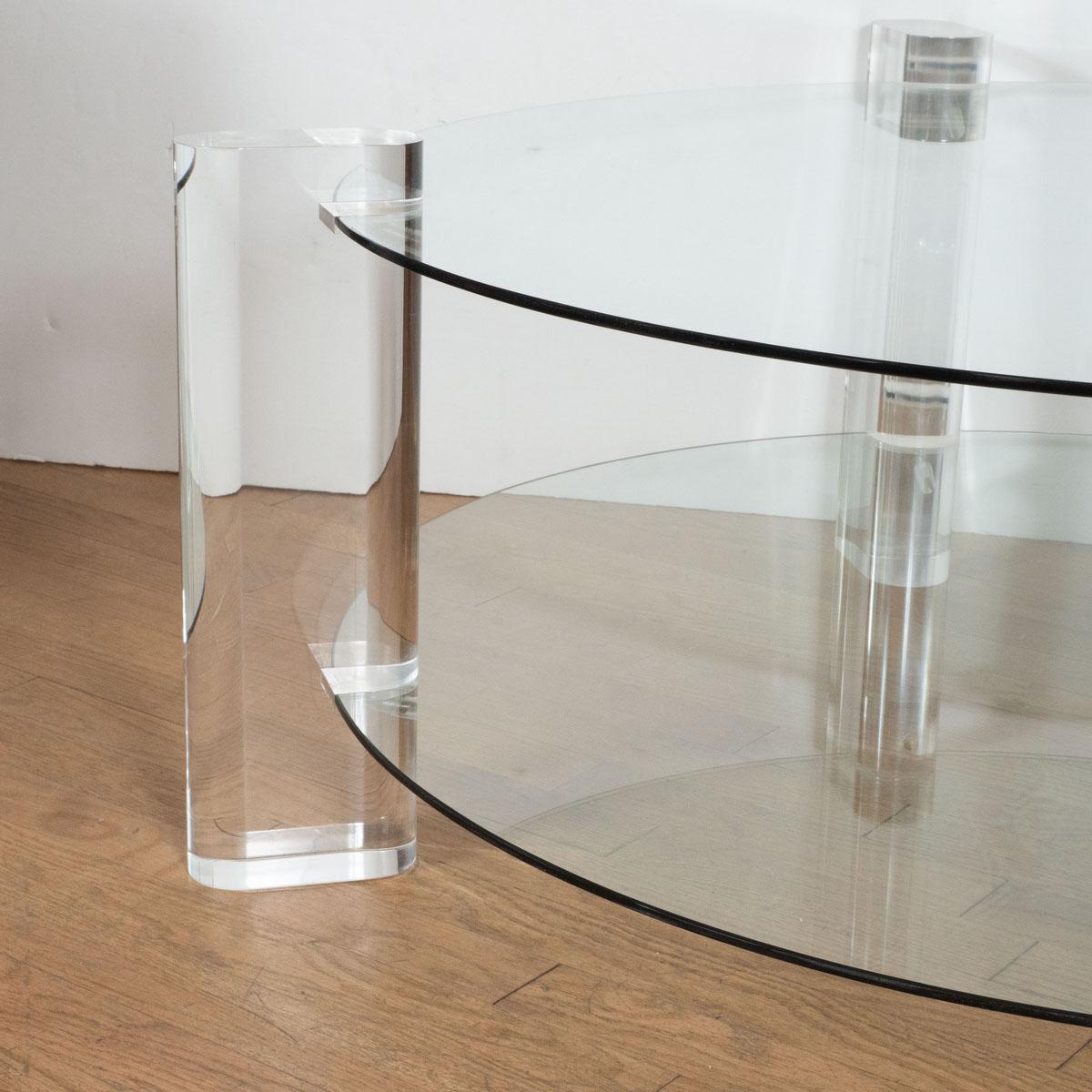 Two tier circular glass coffee table with Lucite supports.