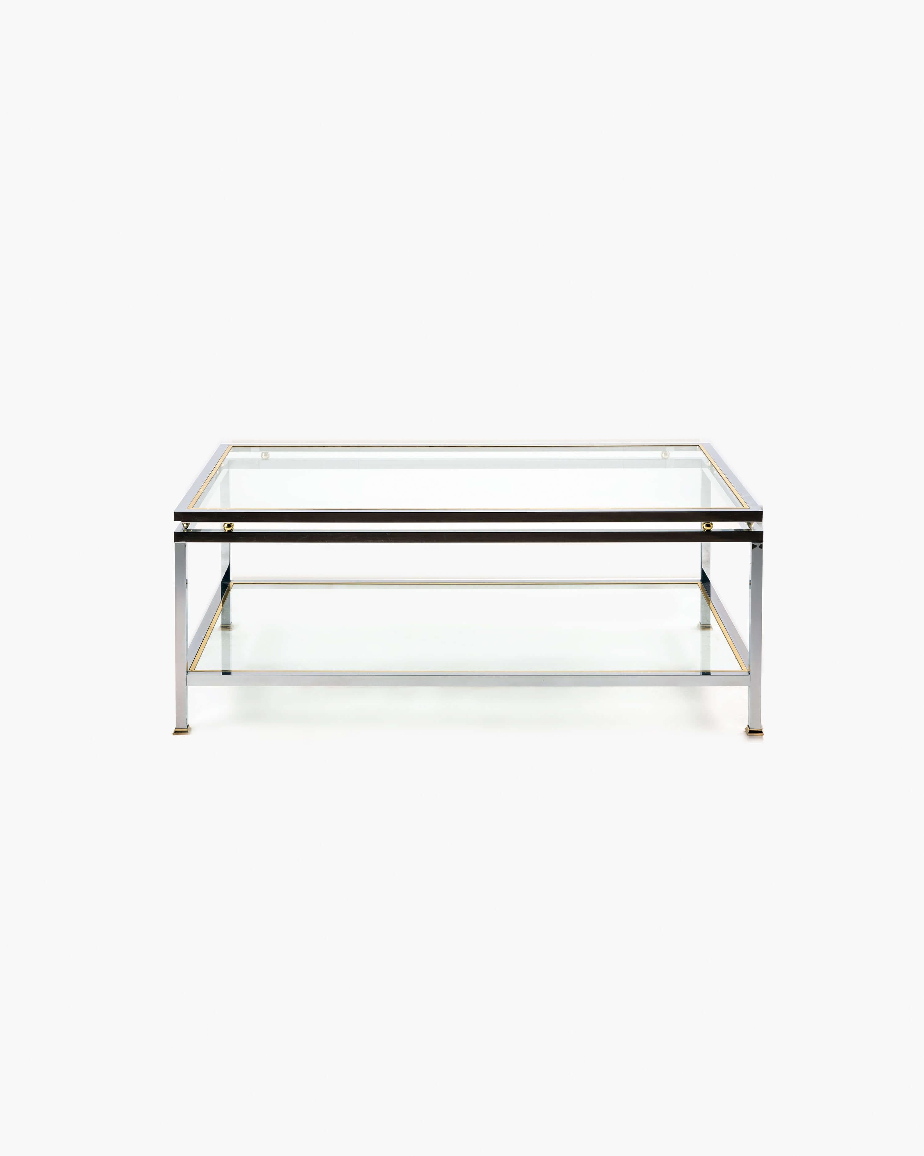 Indulge in the captivating allure of Hollywood Regency with this exquisite two-tier coffee table, expertly designed for Maison Jansen. Crafted in the distinguished French design tradition, this circa 1970 table is a true masterpiece, showcasing a