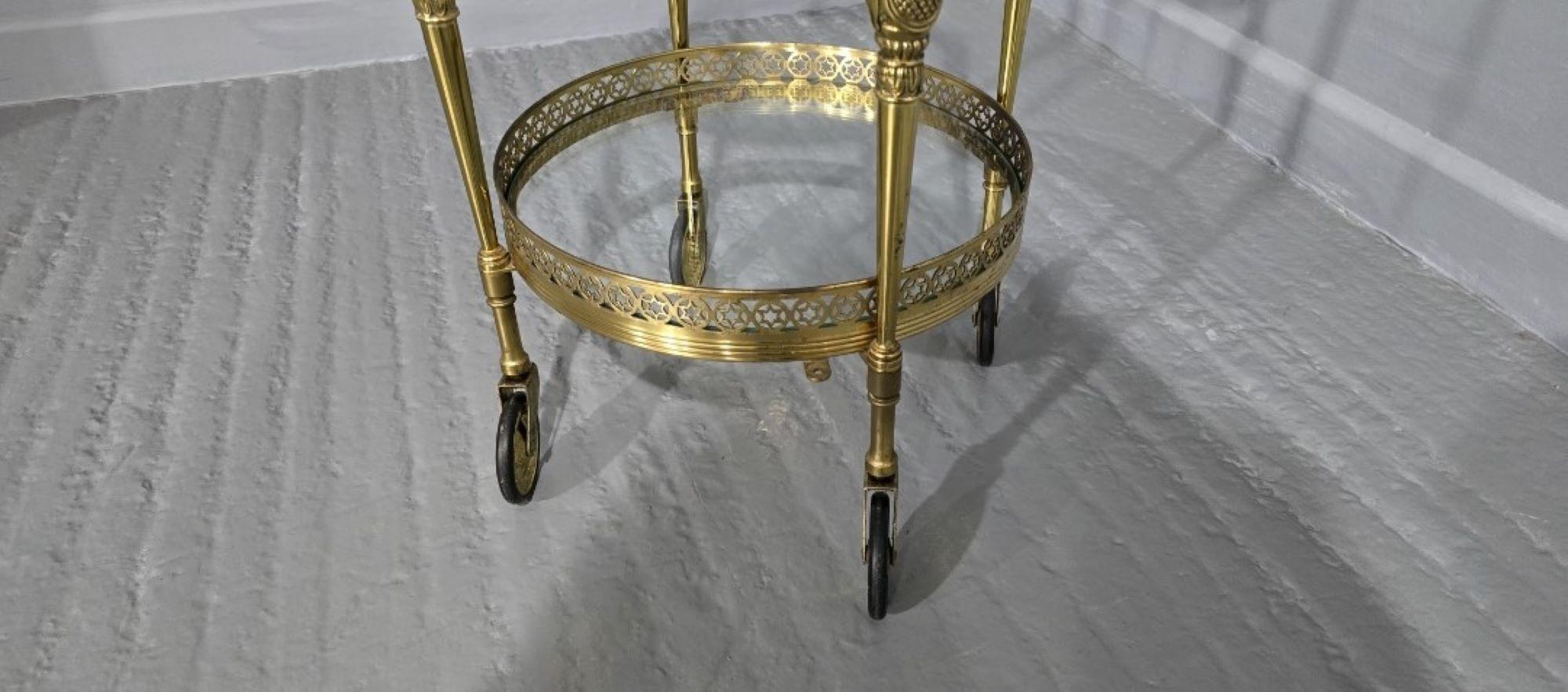 A very nice two tier gilt metal trolley with glass bases, glass two handles lift off tray with gilt metal edge and two handles, in overall very good original condition.

25
