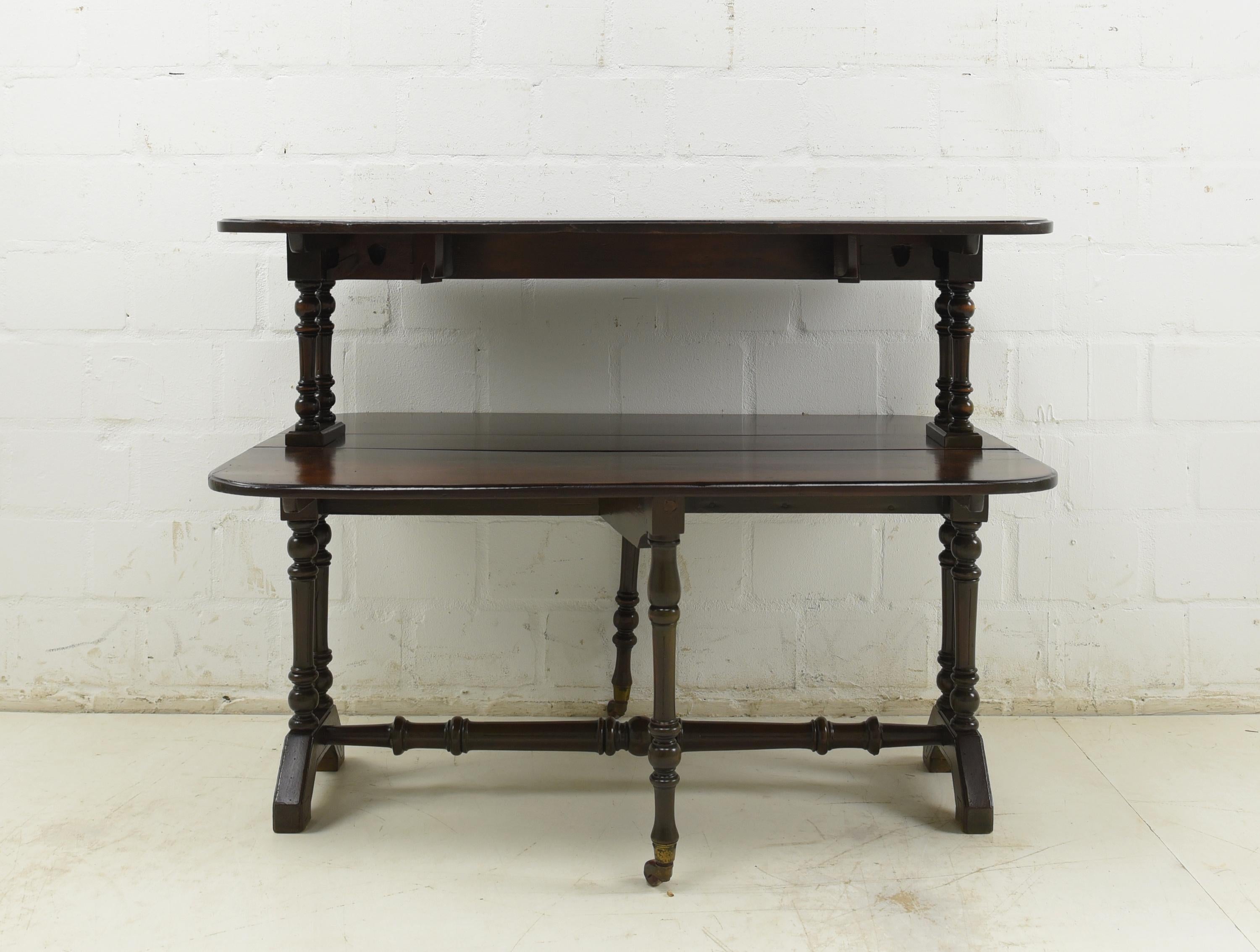 Two Tier Gateleg Folding Table Restored England Mahogany Shelving Table

Features:
Two-storey, shelf-like design
Both plates can be opened and closed on both sides
Beautiful patina
Beautiful grain
Very unusual and rare model

Additional