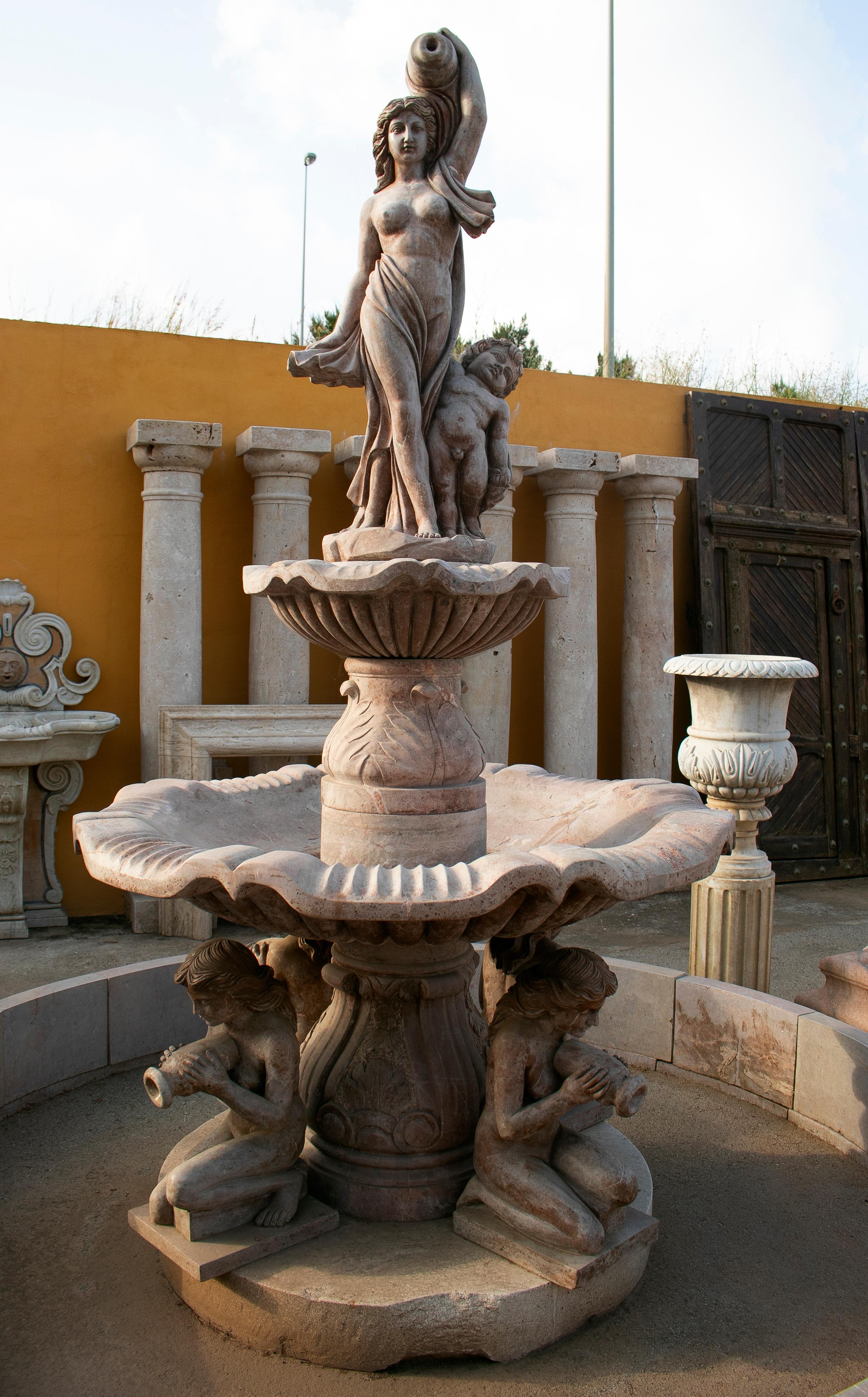 Two tier hand carved brown marble fountain with pool and sculptures.

Fountain dimensions: 305 x 160 x 160 cm
Pool dimension: 34 x 290 cm.