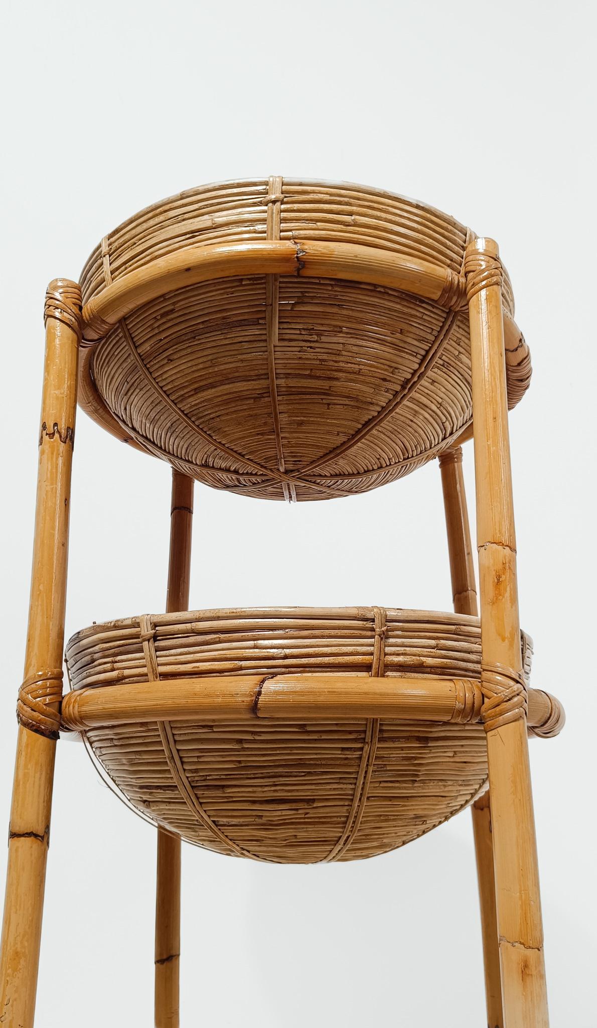 Ponemos a la venta un Soporte para Plantas vintage, fabricado en Italia entre los años 60 y 70.
Dentro de la estructura, hecha de gruesas cañas de bambú y atada con bellos tejidos geométricos de piel de ratán, hay dos grandes cestos, cada uno de 48