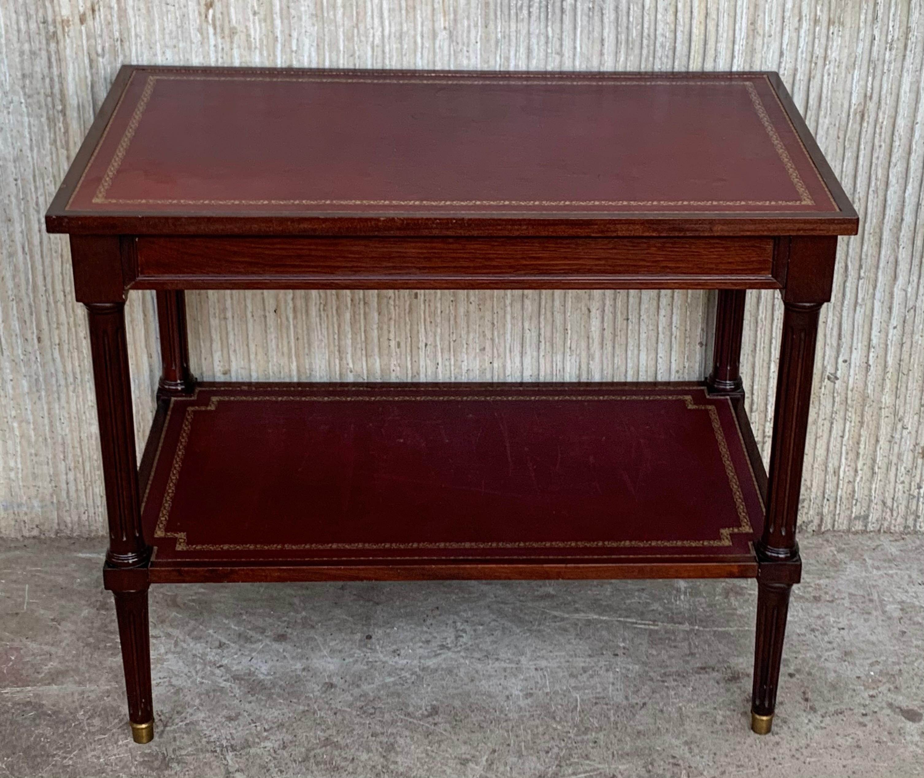 Two-tier red leather with gilt tooled top Empire end table in mahogany.