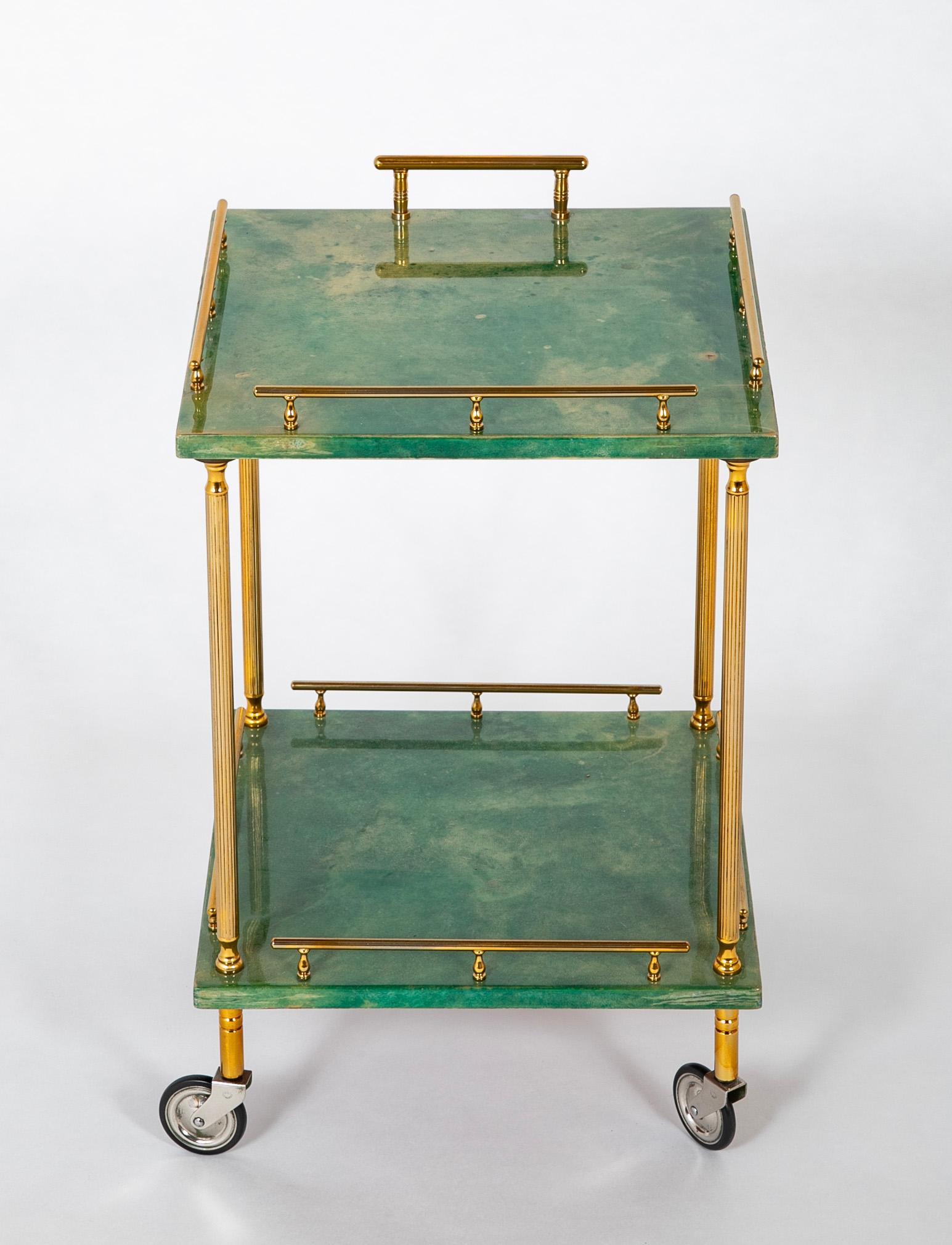 A two tier rolling bar cart having green lacquered goatskin shelves and polished high quality brass galleries. 

Corallo, Italy
