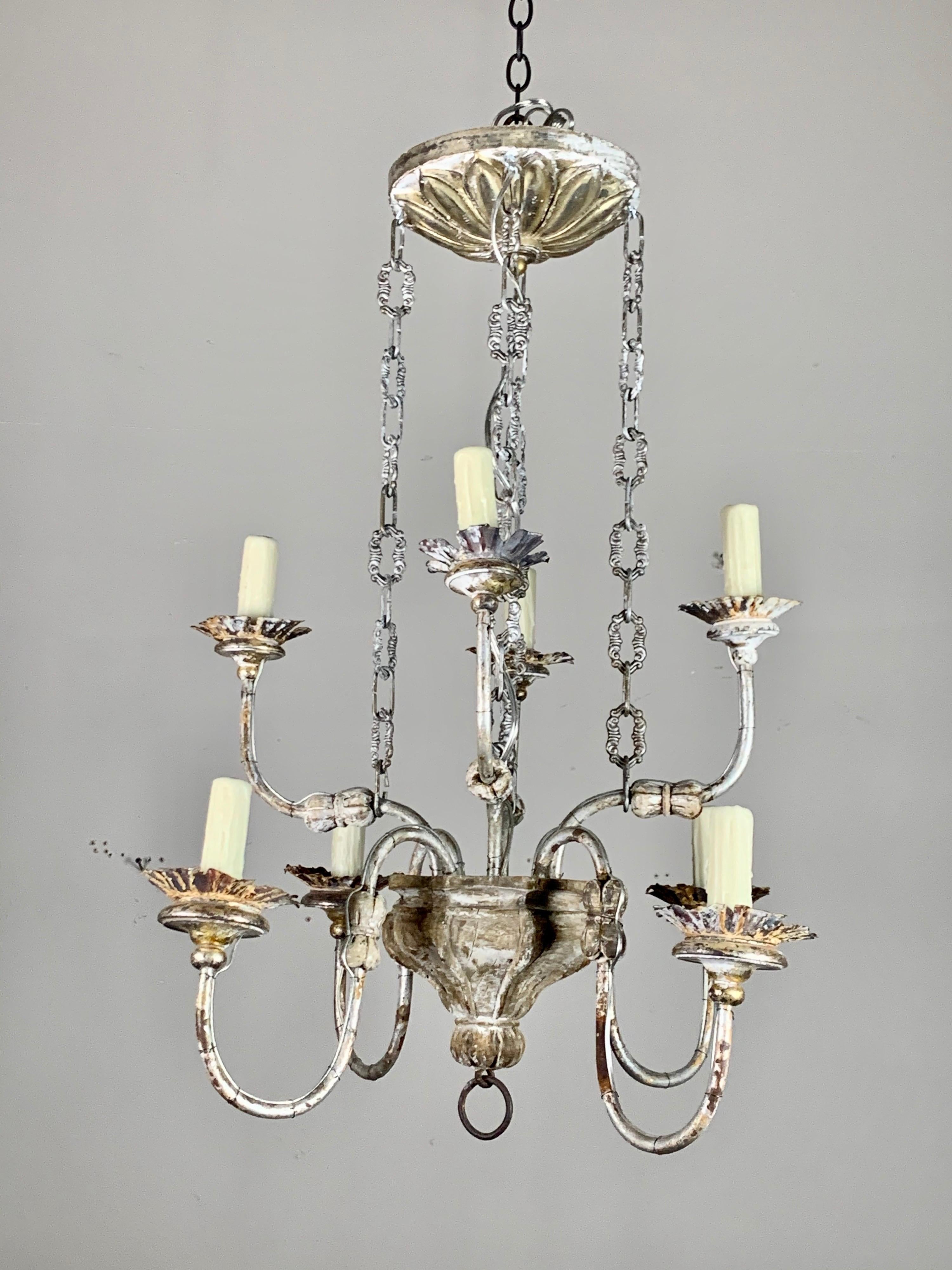 Two-tier Italian silvered eight-light chandelier caved in wood with metal arms and chain. The fixture is newly rewired with grip wax candle covers. Includes chain and beautiful hand carved giltwood canopy.