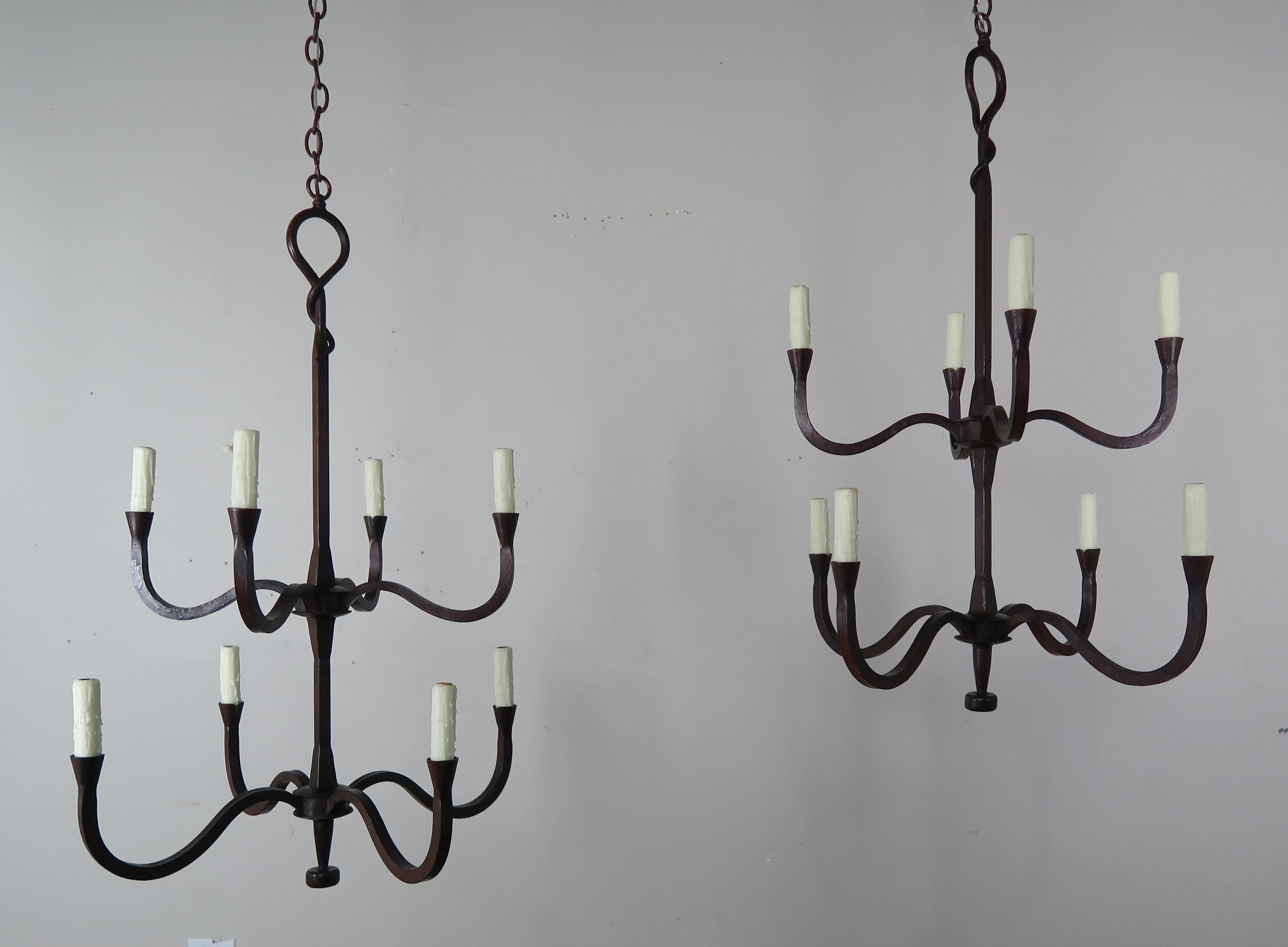 Two-tier eight light Spanish style handwrought iron chandelier finished in an antique iron finish. The chandelier is newly wired with cream drip wax candle covers. The chandelier is made in two sizes but any size or custom finish can be done per