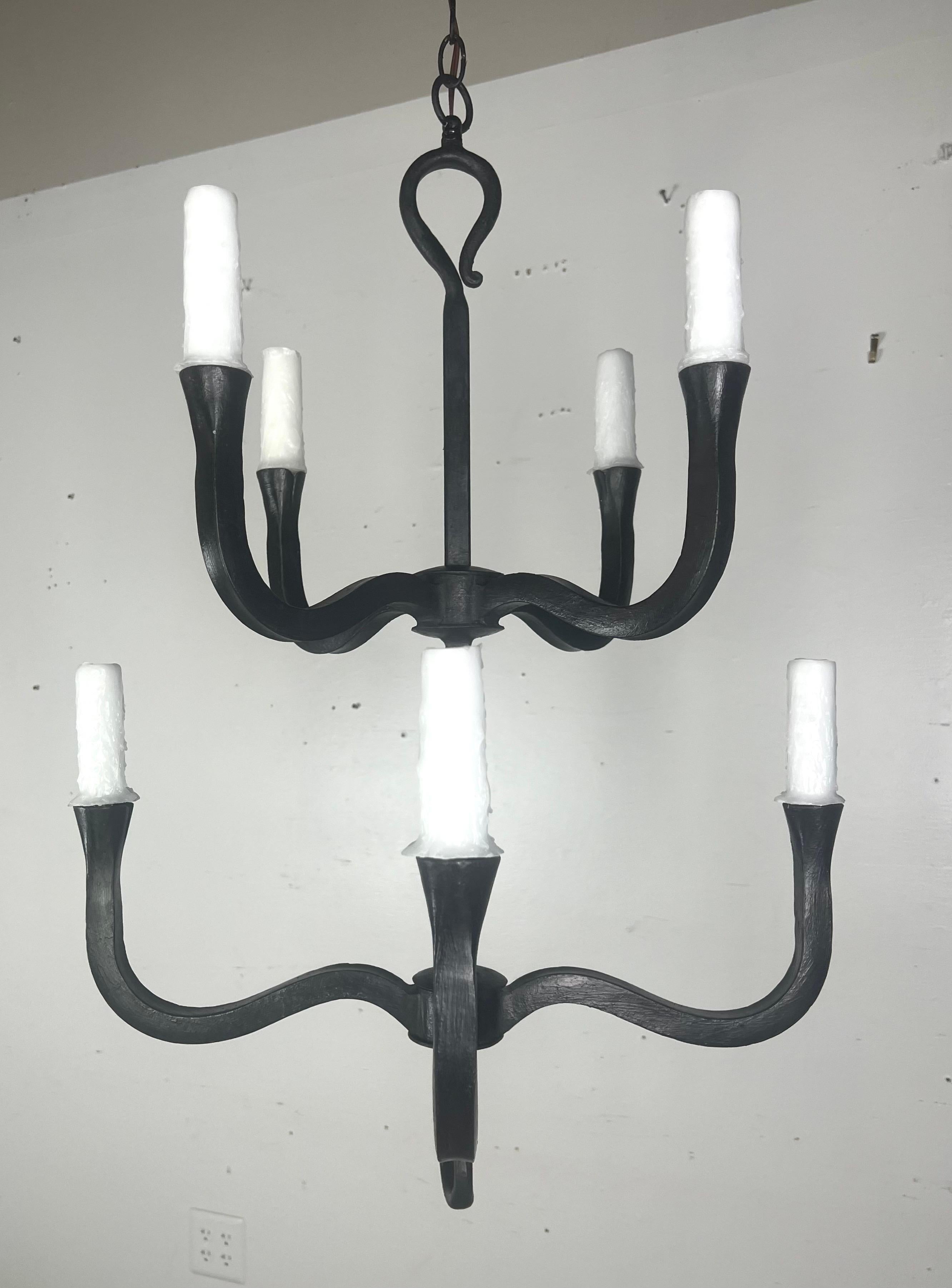 Custom two-tier wrought iron chandelier by Melissa Levinson.  This chandelier has a classic, elegant structure.   It has eight arms, each curving gracefully to hold a drip wax candle at the end.  The chandelier is wired and has chain and a