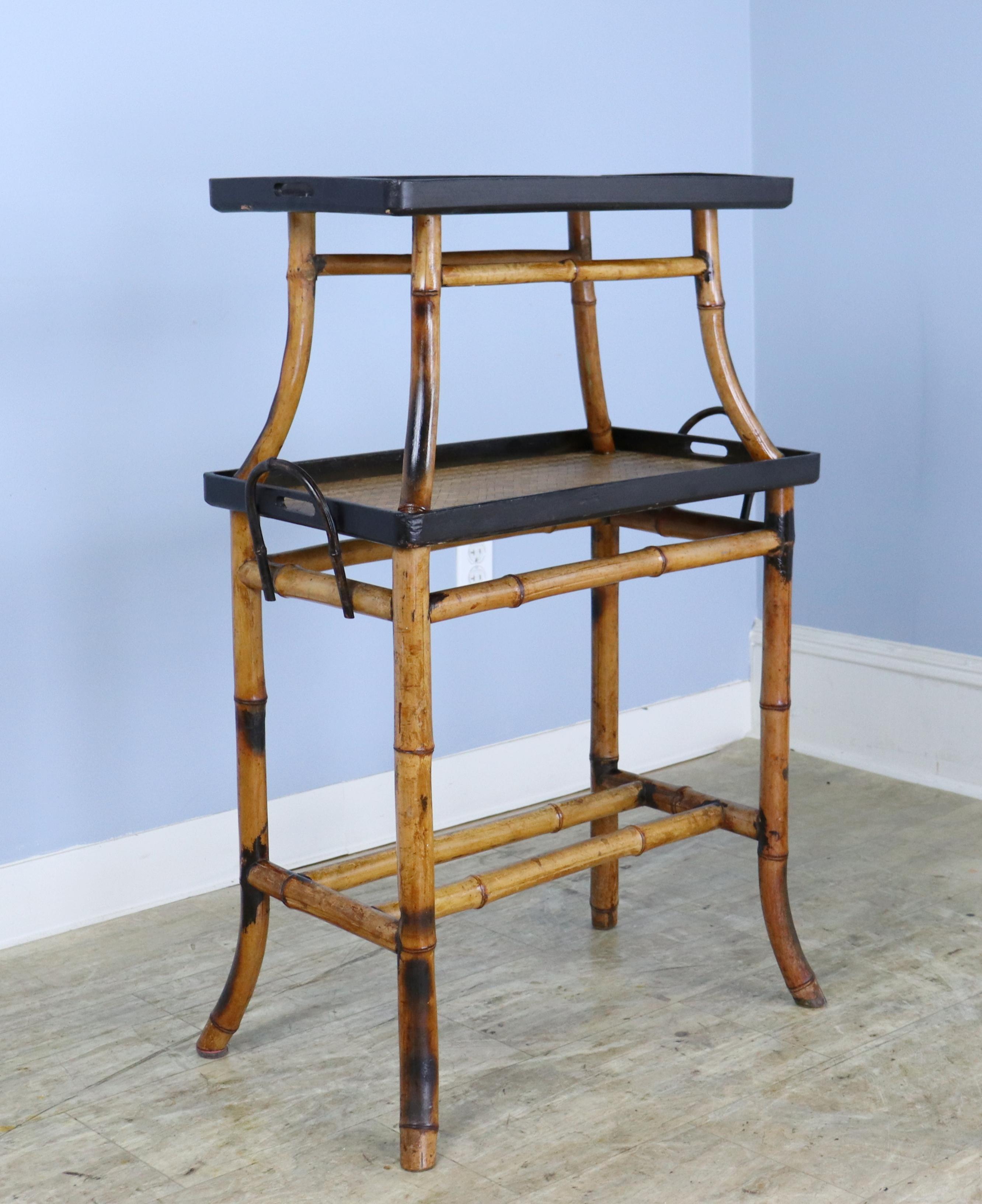 A charming two tier serving table in vibrant bamboo.  The rattan on both shelves seems new.  Oodles of character and  versatile to boot.  Width and depth measurements are for the longest distances at the tips of the flared legs.