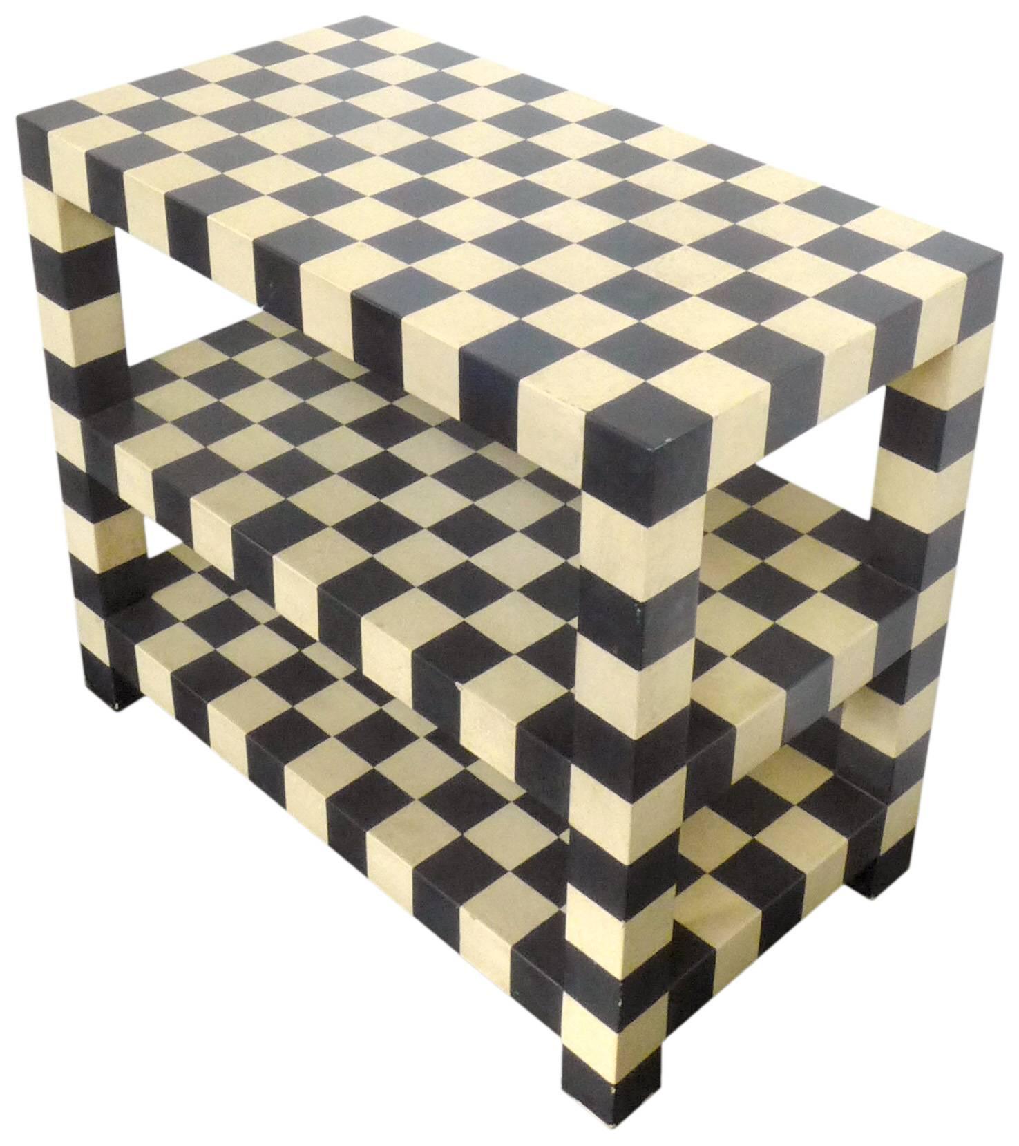 A spectacularly graphic, two-tiered checkerboard table. A strong, architectural form of lacquered wood, in alternating black and warm-white squares. Great scale and proportions. This table could function well as either a small console, occasional or