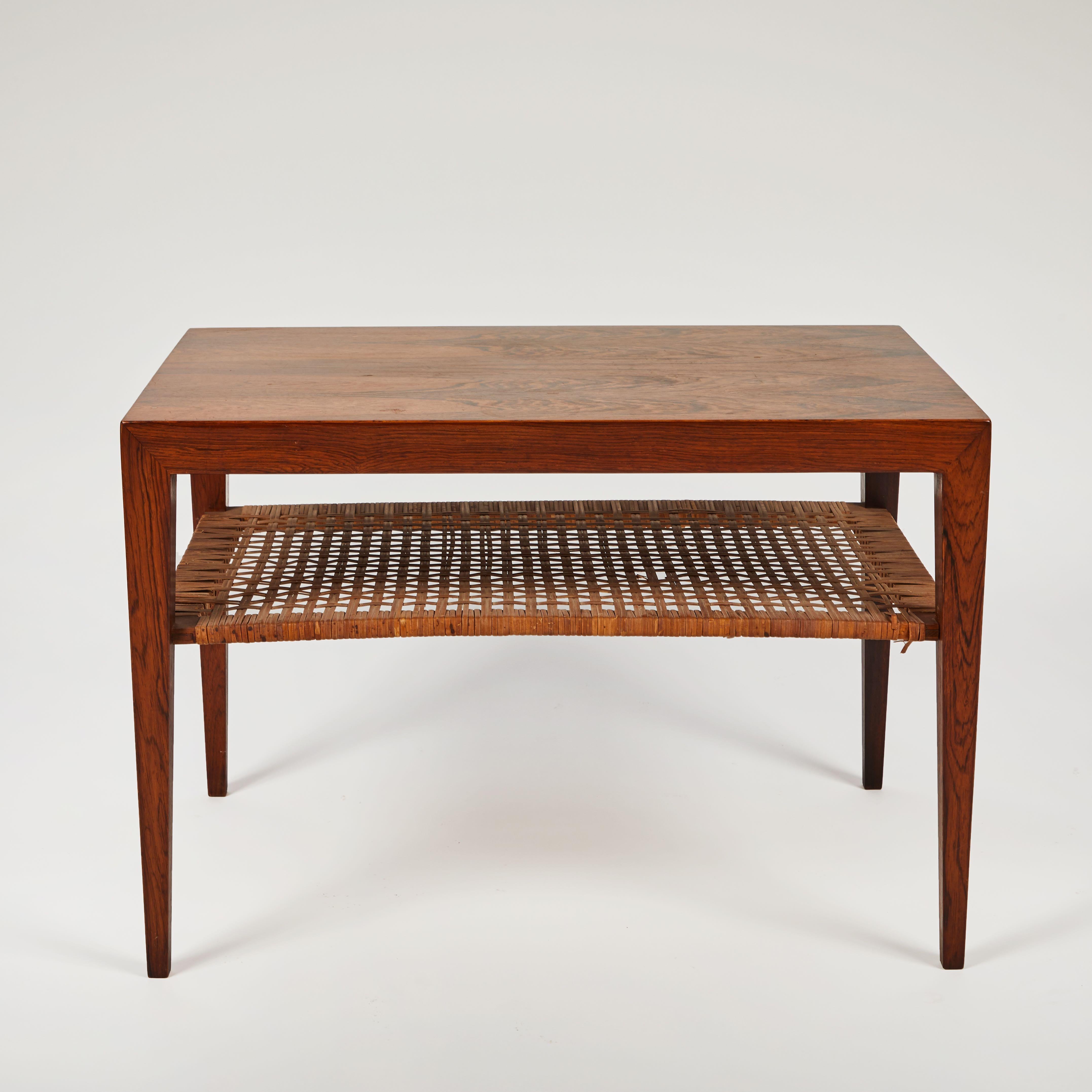 Two-tiered mid-century walnut coffee or end table with rattan shelf.