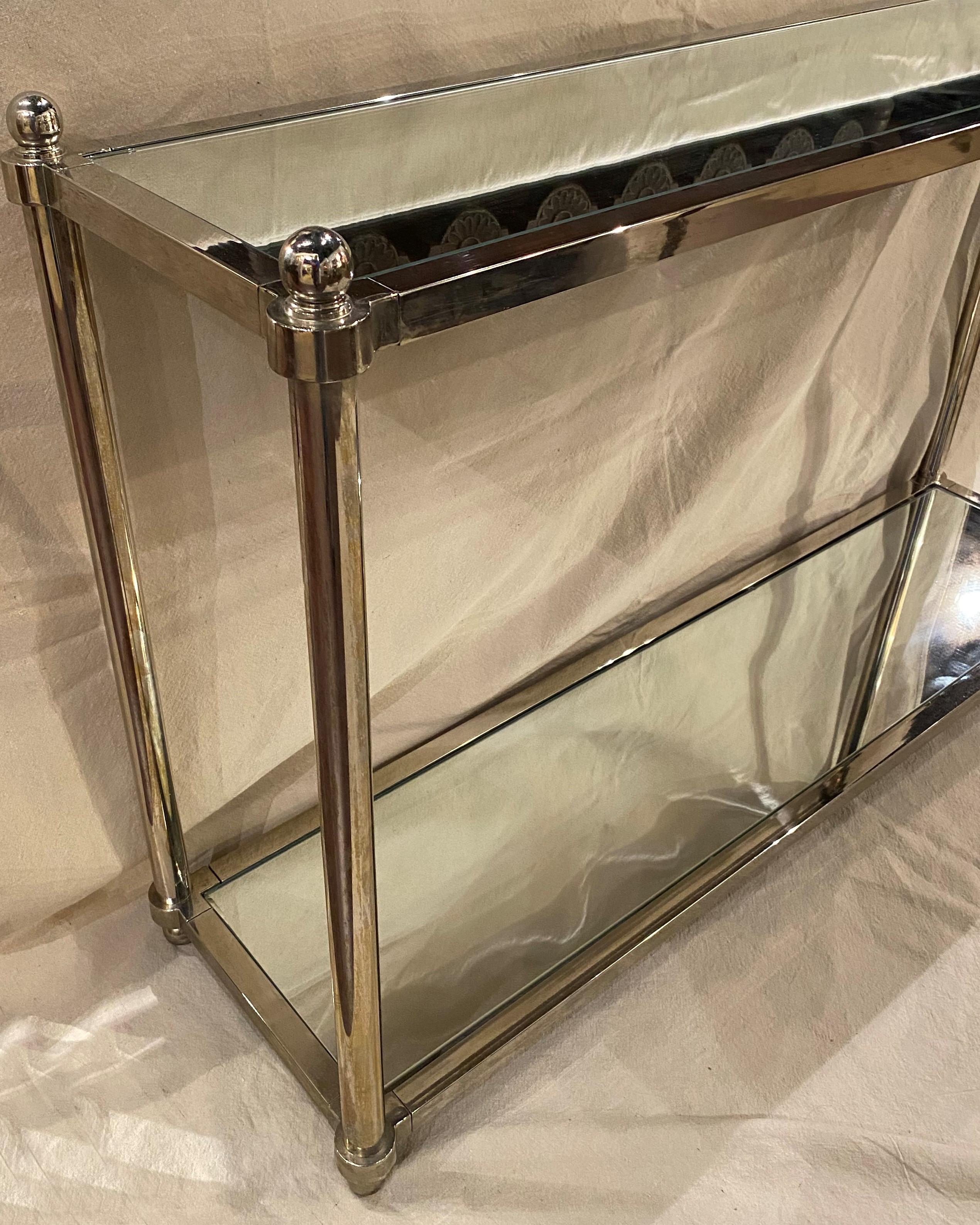A fine Milo Baughman style two tiered chrome console or sofa table with removable mirrored glass shelves, unsigned. This table probably dates to the 1970’s and is in very good condition, with some surface imperfections, minor chrome tarnish, and
