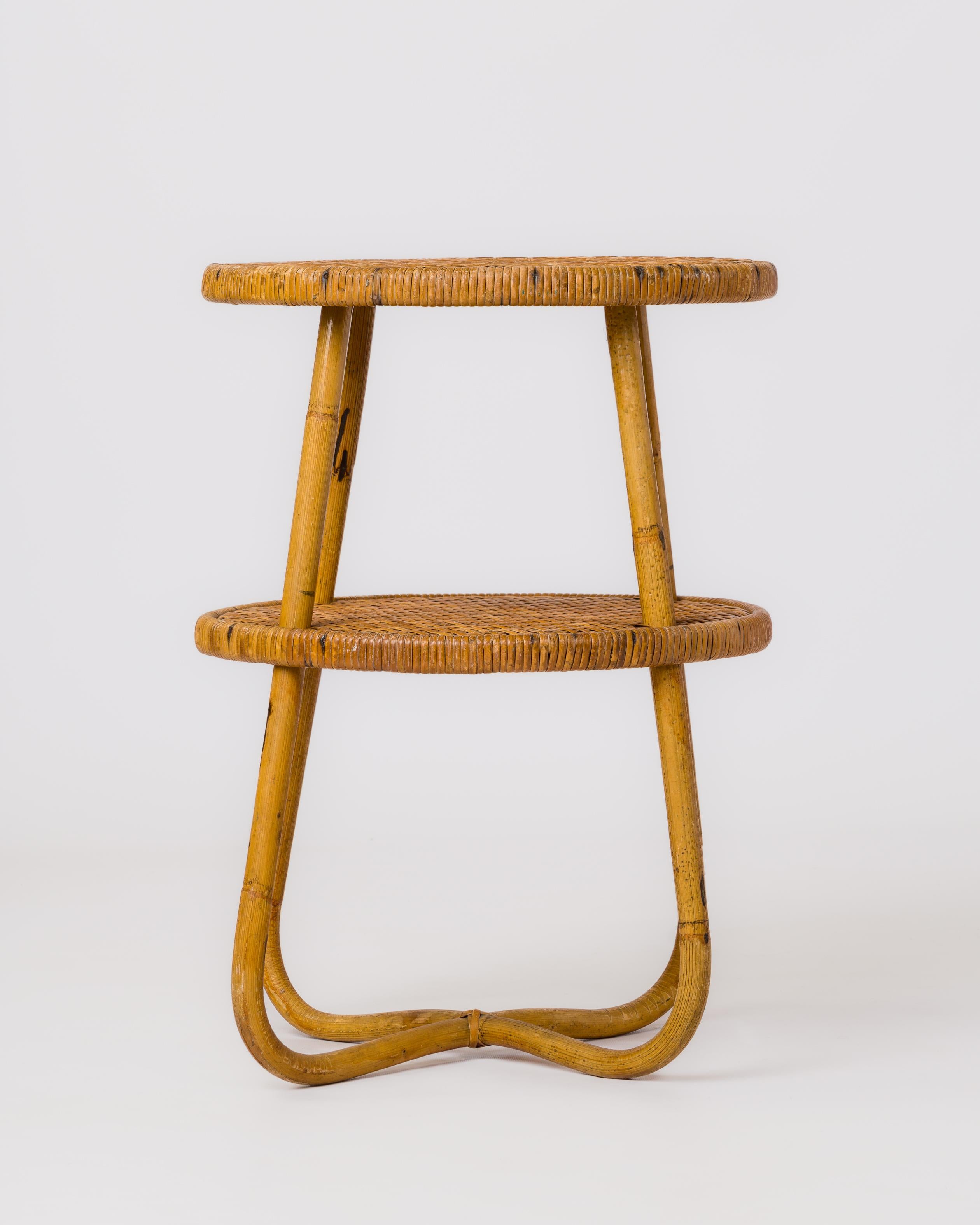 Elegante tavolo con piedistallo a doppio piano in rattan e canna intrecciata. Gambe a forma di croce e una struttura di supporto che abbraccia il piano inferiore.
In buone condizioni vintage.
Questo gueridon sarà spedito dalla Francia e potrà essere