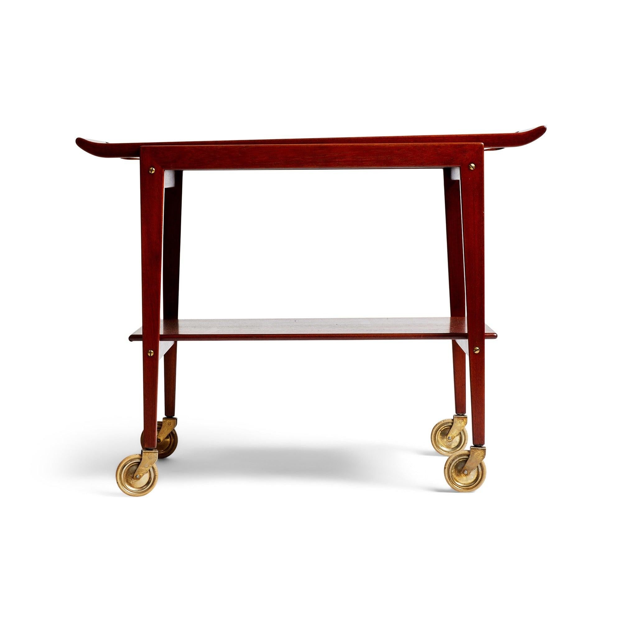 An architectural teak cart with a removable tray and single shelf on brass casters.