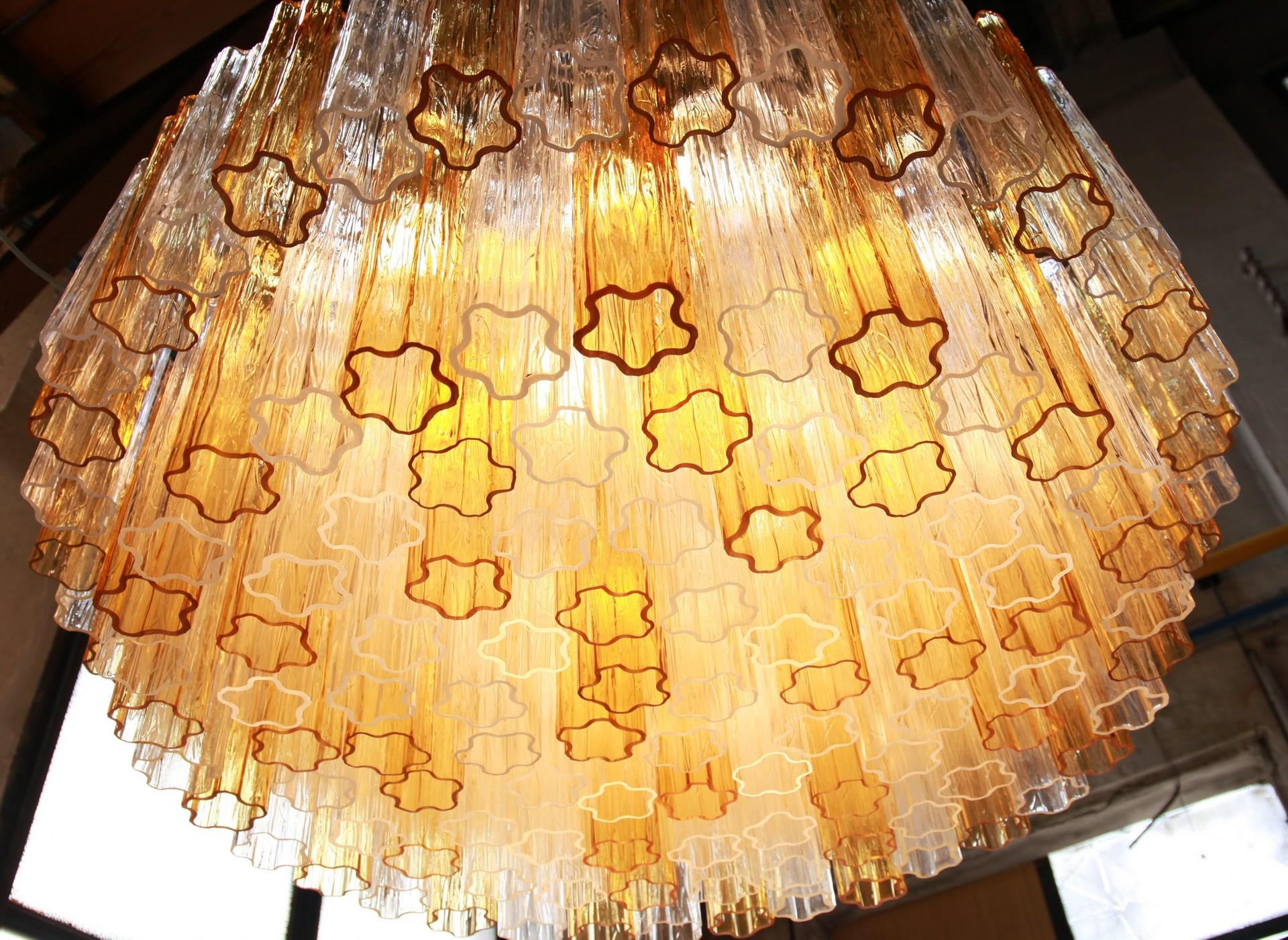 Classic combination of clear and amber with a proportion of 2 clear and one amber and clear and taupe grey. The cut at the bottom of each element is highlighted when lit, see pictures. There are more than 120 glass Murano glass blown elements.