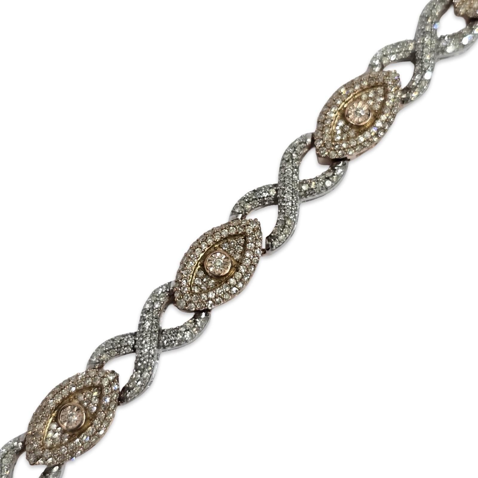 Questo squisito braccialetto di diamanti bicolore, che emana eleganza e un tocco di romanticismo, è una dichiarazione di lusso raffinato. Realizzato in oro rosa e bianco 10 carati, il design presenta maglie intrecciate in stile infinito, che
