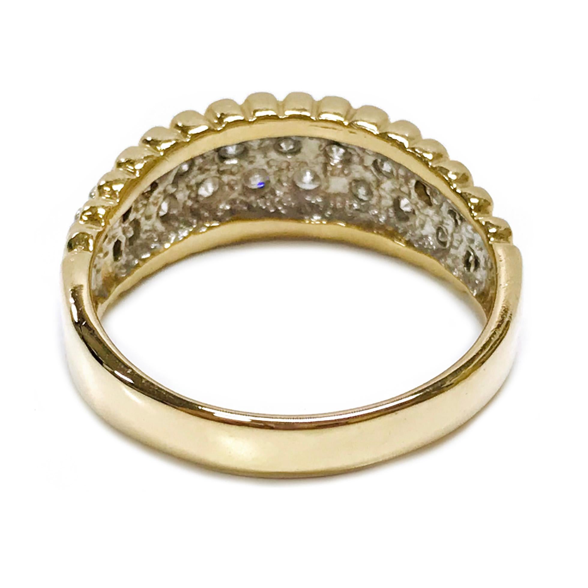 Two-Tone 14 Karat Gold Diamond Pavé Ring. The elegant ring features two rows of round graduate diamonds set in pave in white gold. The yellow gold band has scalloped edges along the top and bottom where the diamonds are set in the middle. The