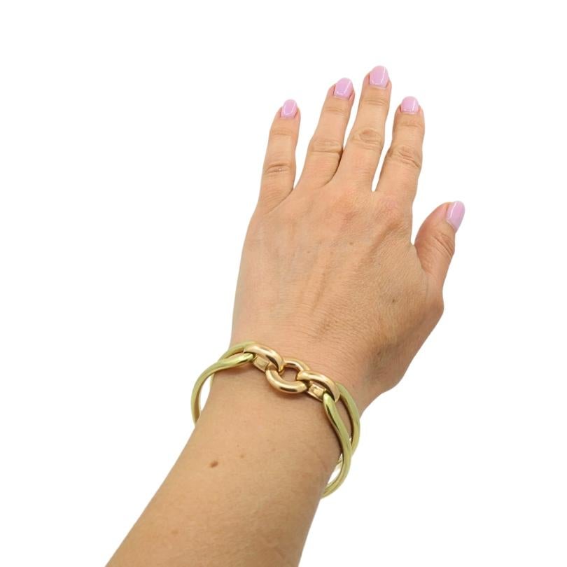 Ce bracelet en or 14 carats est une pièce d'affirmation audacieuse et élégante, présentant un design d'inspiration vintage avec des maillons imbriqués substantiels. Le bracelet combine l'or jaune et l'or rose dans un jeu de couleurs saisissant. Les