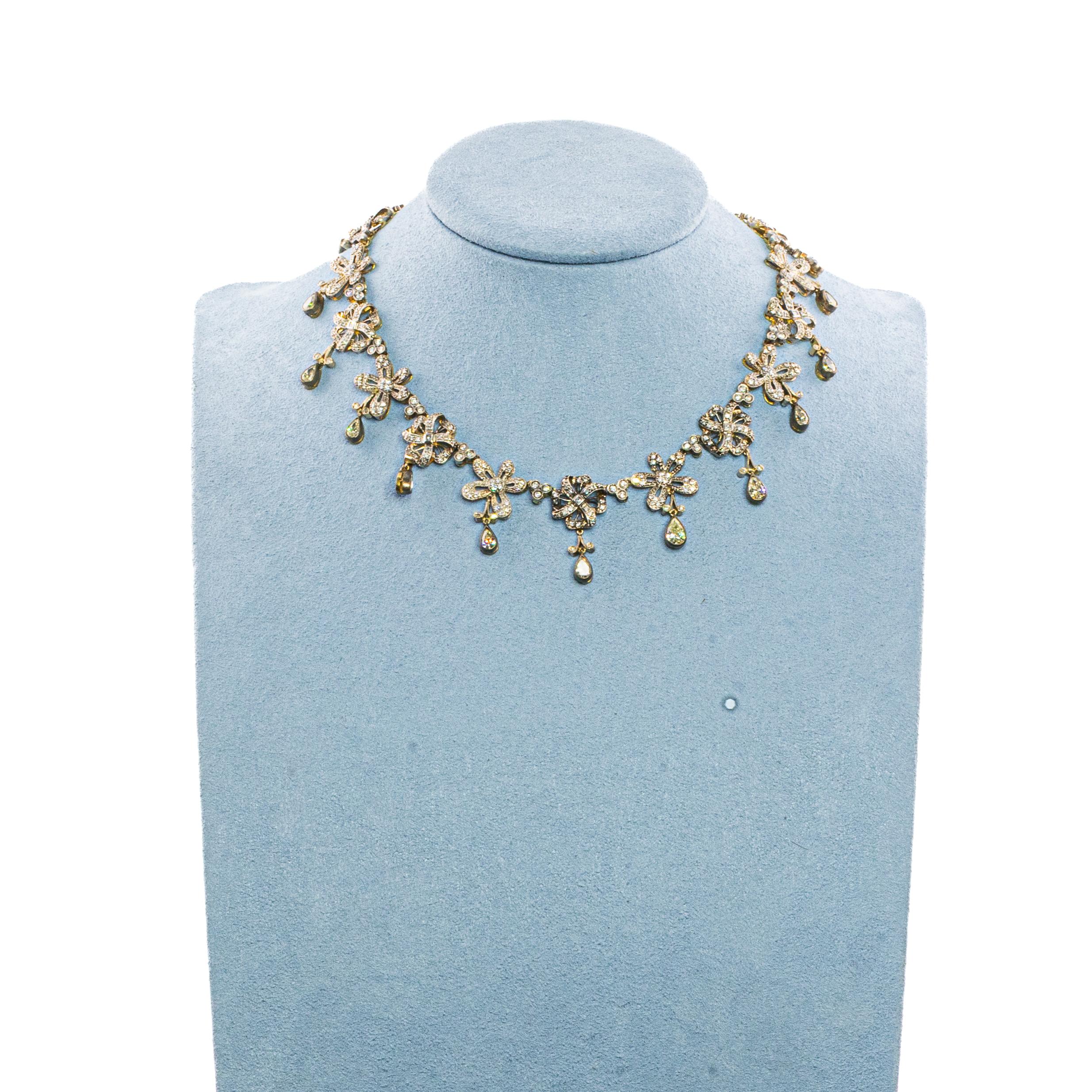 Two-Tone 18 Karat Gold Diamond Floral Necklace

Description:
An elegant floral-inspired necklace crafted in 18 karat two-tone gold, designed with a sequence of delicate blossoms and accented with luminous diamond drops. The piece is set with 17