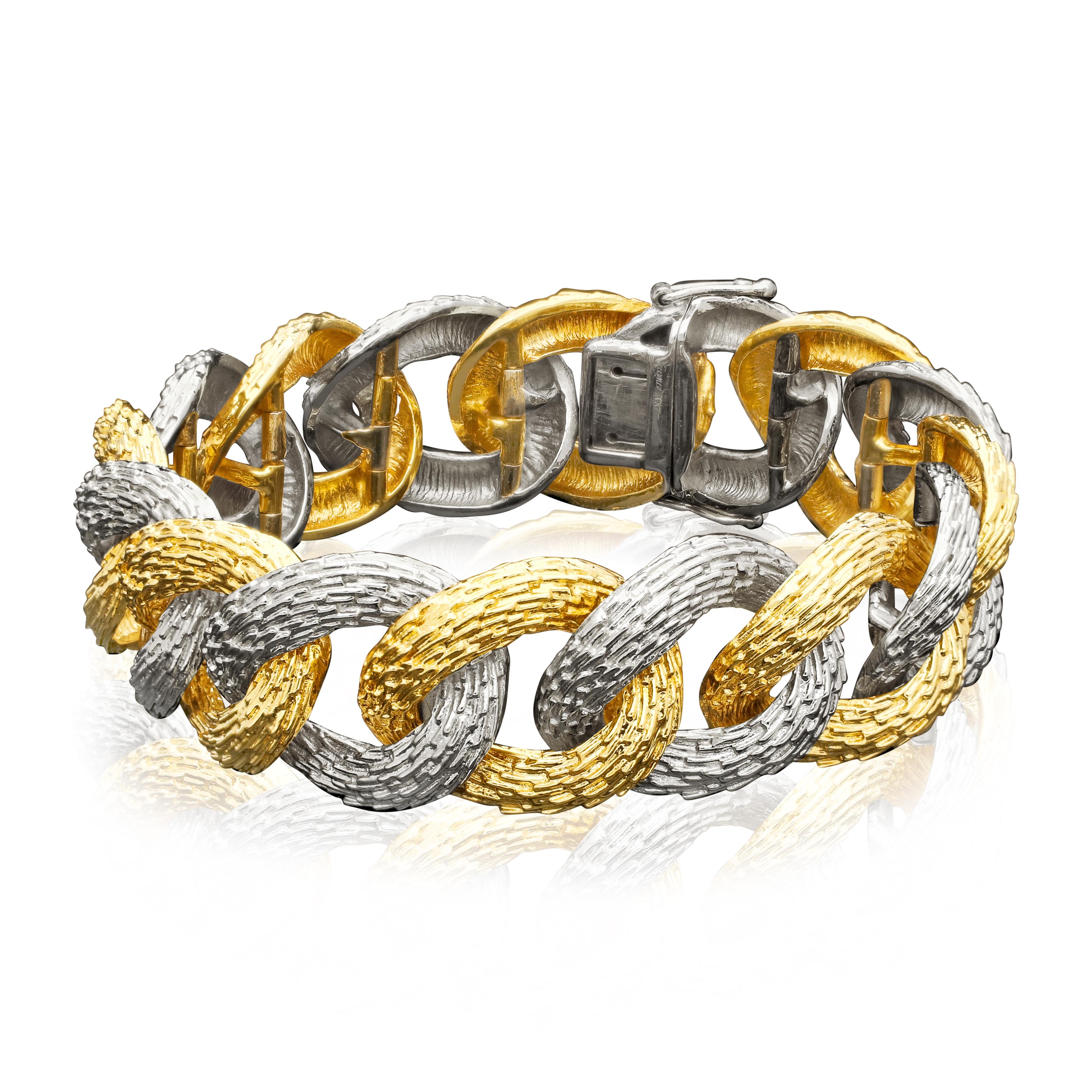 A stylish French vintage two tone gold bracelet c.1970s, composed of sixteen uniform links in heavily textured 18ct yellow or white gold arranged alternately, to a concealed tongue and box clasp. A classic style of the period, this bracelet is the