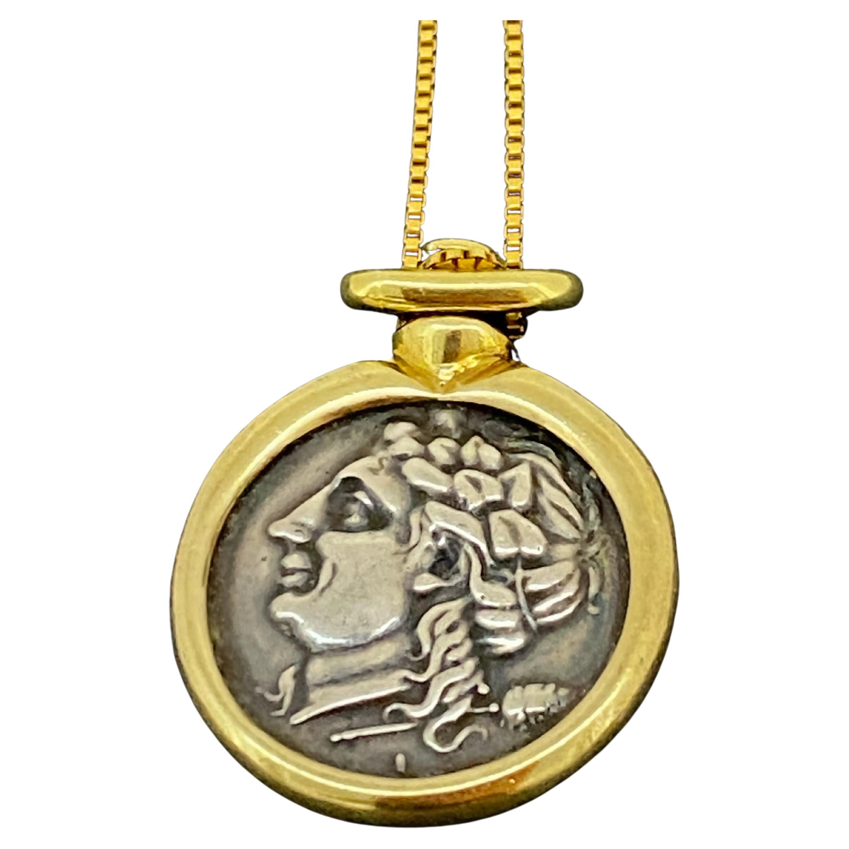 This vintage Two-Tone 18K Yellow Gold Pendant
is designed as an ancient Greek Coin, 
depicting Hercules - 
Roman equivalent of the Greek divine hero Heracles 
(who was famous for his strength & far-ranging adventures), 

encased in 18K yellow gold