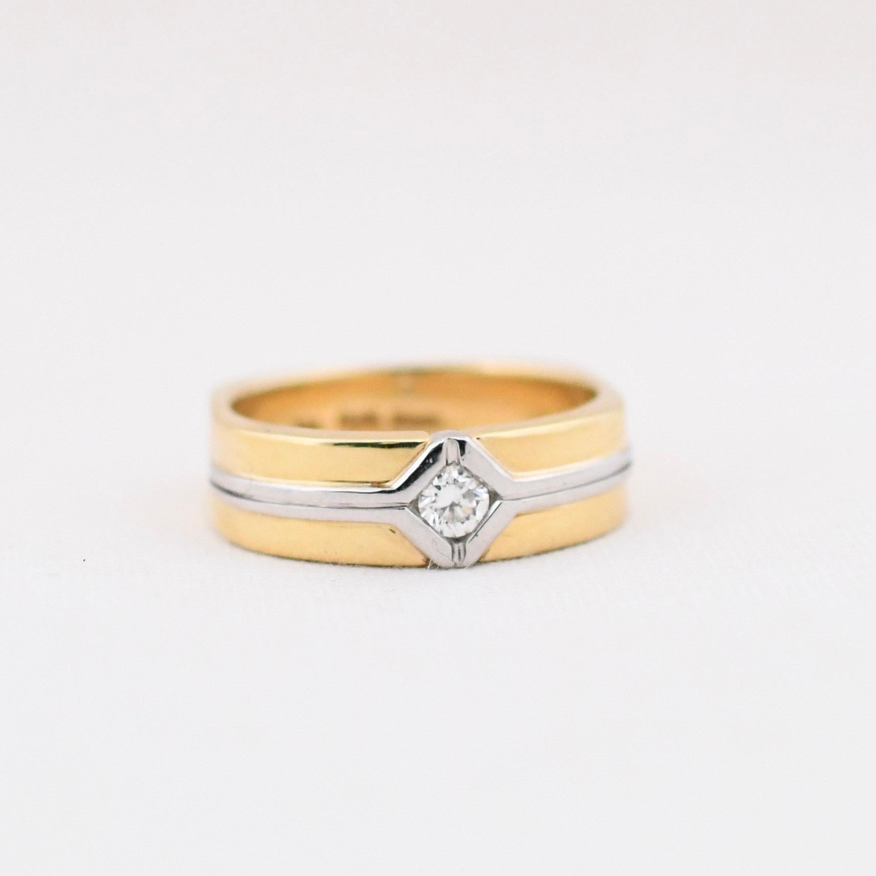 Here we have a stunning men's wedding band. With a two-tone design, the platinum and 18K yellow gold work as a team giving a timeless geometric design. Predominantly yellow gold there is a platinum inlay splitting the gold and surrounding the