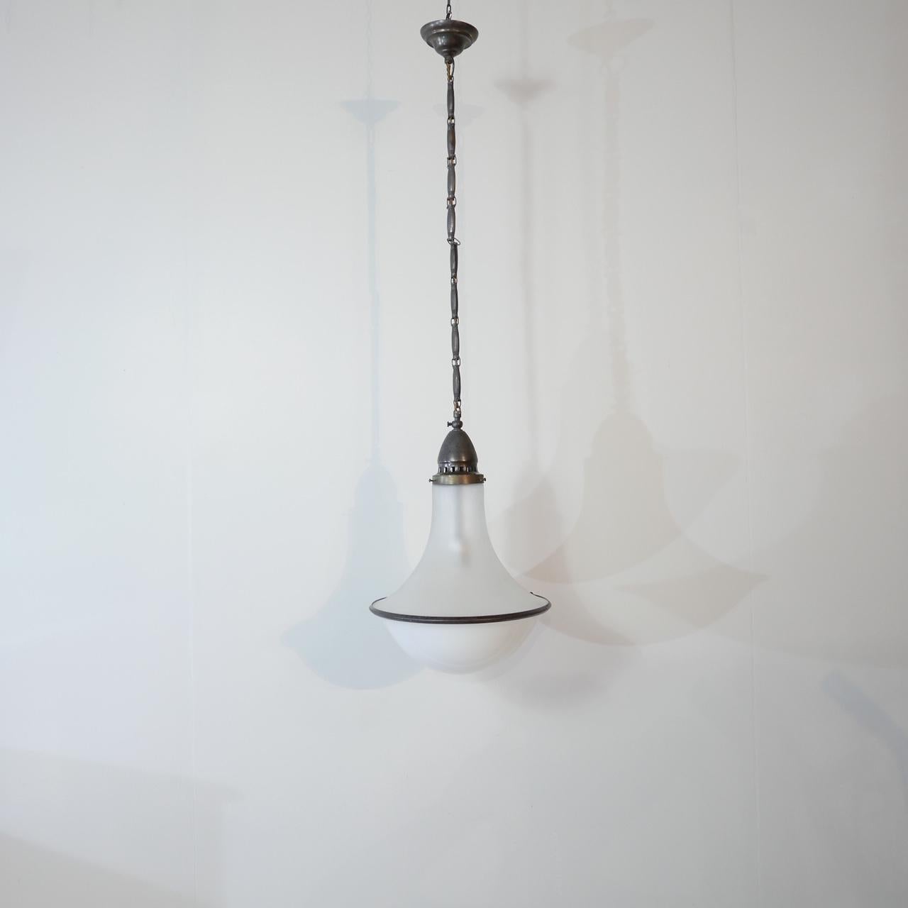 A two tone pendant light.

Opaline base, etched glass top, patinated brass rim and gallery.

Original chain and gallery retained.

A rare model we have not seen before. The chain is reminiscent of Siemens and Schukert.

Early 20th century,