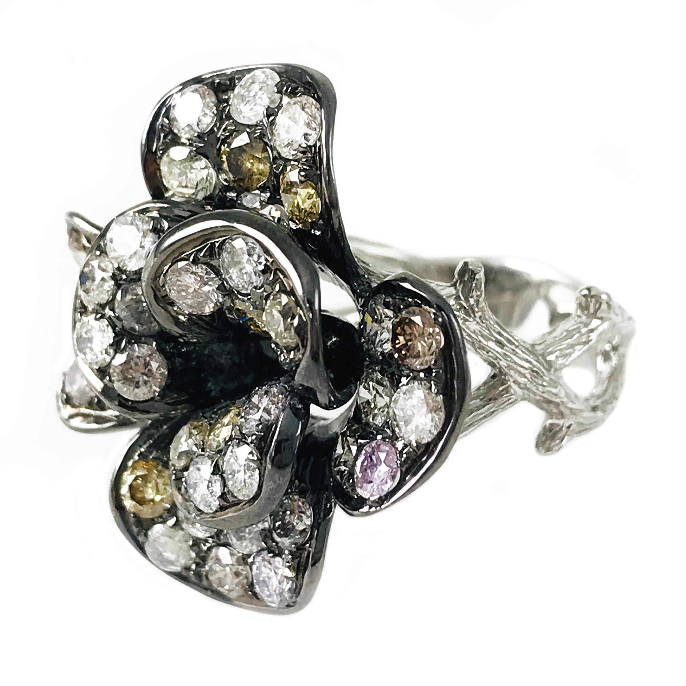 Two-Tone 14 Karat Diamond Flower Ring with a black Rhodium finish to accent the different hues in the natural diamonds. The unique and lovely ring features two tiers of flower pedals with white, pink, yellow and champagne diamonds. The shank is 14