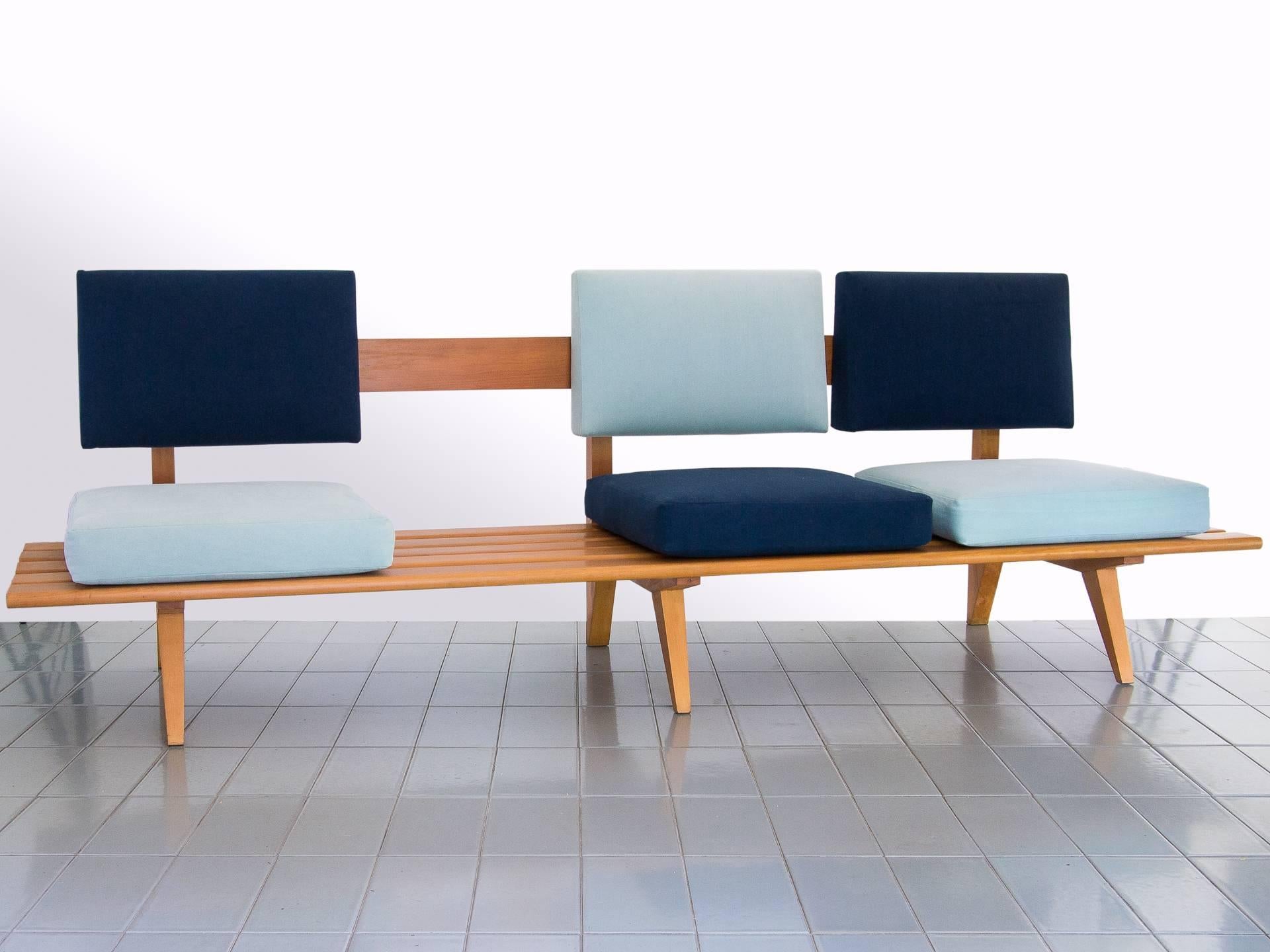 This exquisite and unique sofa is constructed in solid Pau Marfim wood, and has three seats distributed asymmetrically, leaving a gap in one side that can be used as a table. The two tones of blue are original to the piece, but we replaced the