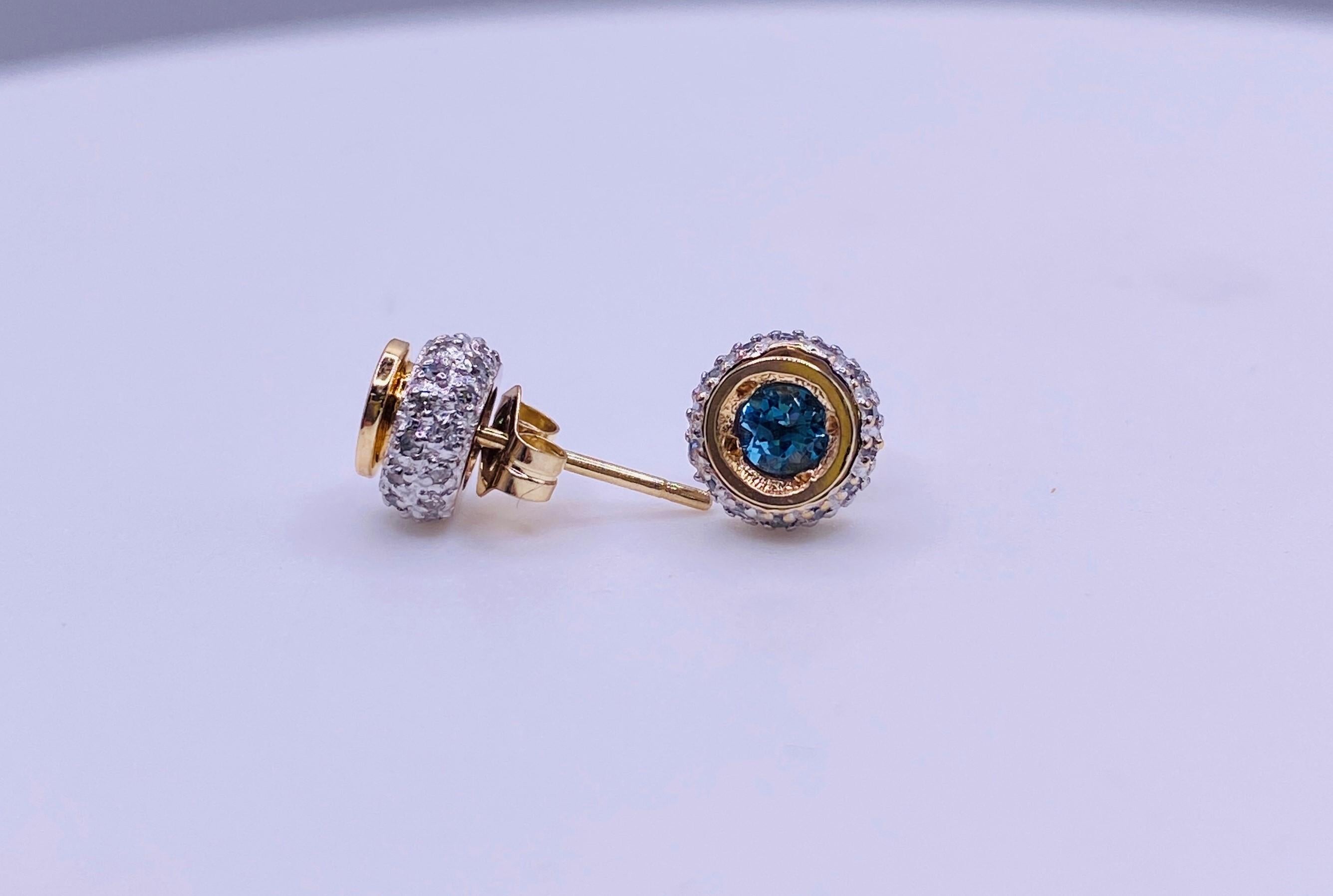 14k two tone stud earrings with .28 carat total weight blue topaz and .32 carat total weight diamonds. 