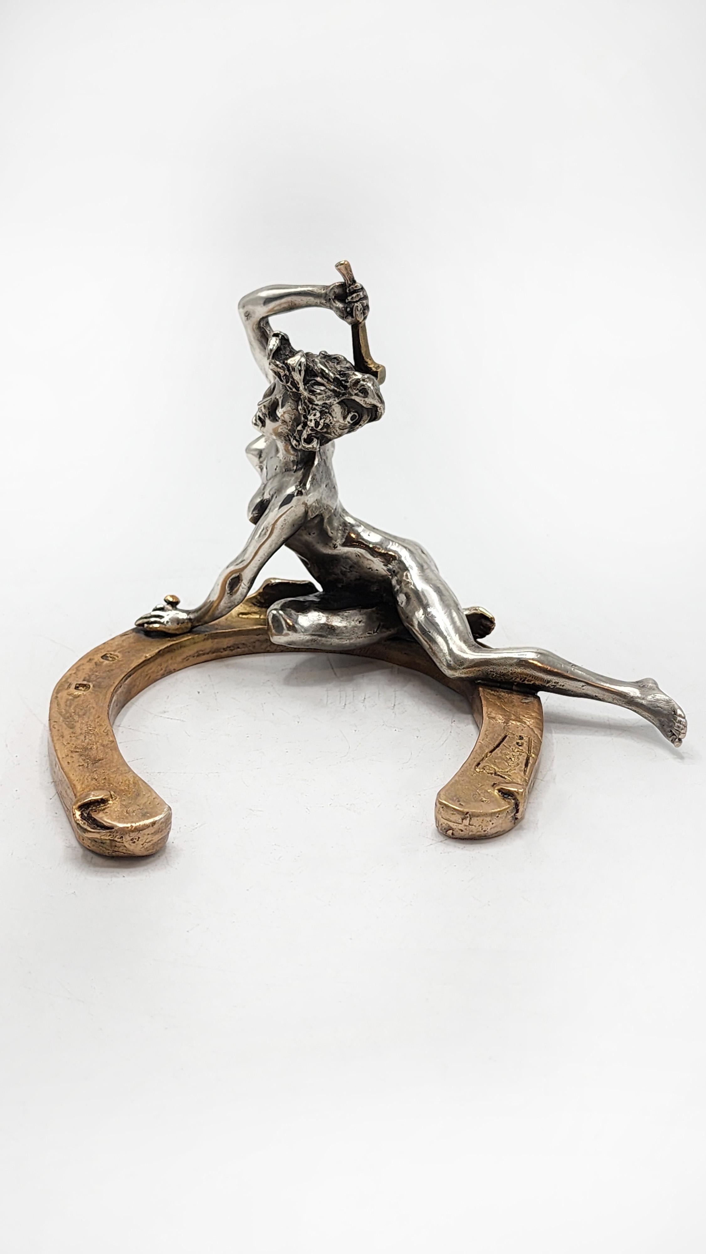 Two-Tone Bronze Sculpture by Georges Recipon
Two-tone bronze sculpture depicting a dynamic and sensual female figure seated on golden hardware. The woman, with a shiny silver finish, has one arm raised holding a hammer, while the other arm rests on