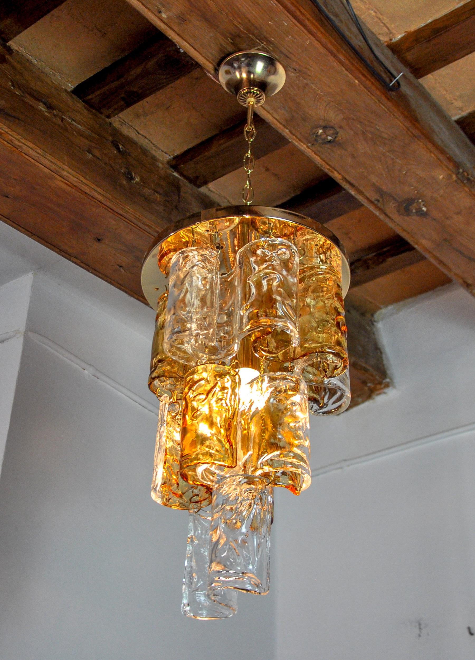 Superb and rare zero quattro chandelier designated and produced in the 70s in murano, italy. Golden structure and orange curved crystals spread over 3 levels in perfect condition. Rare design object that will illuminate your interior perfectly.