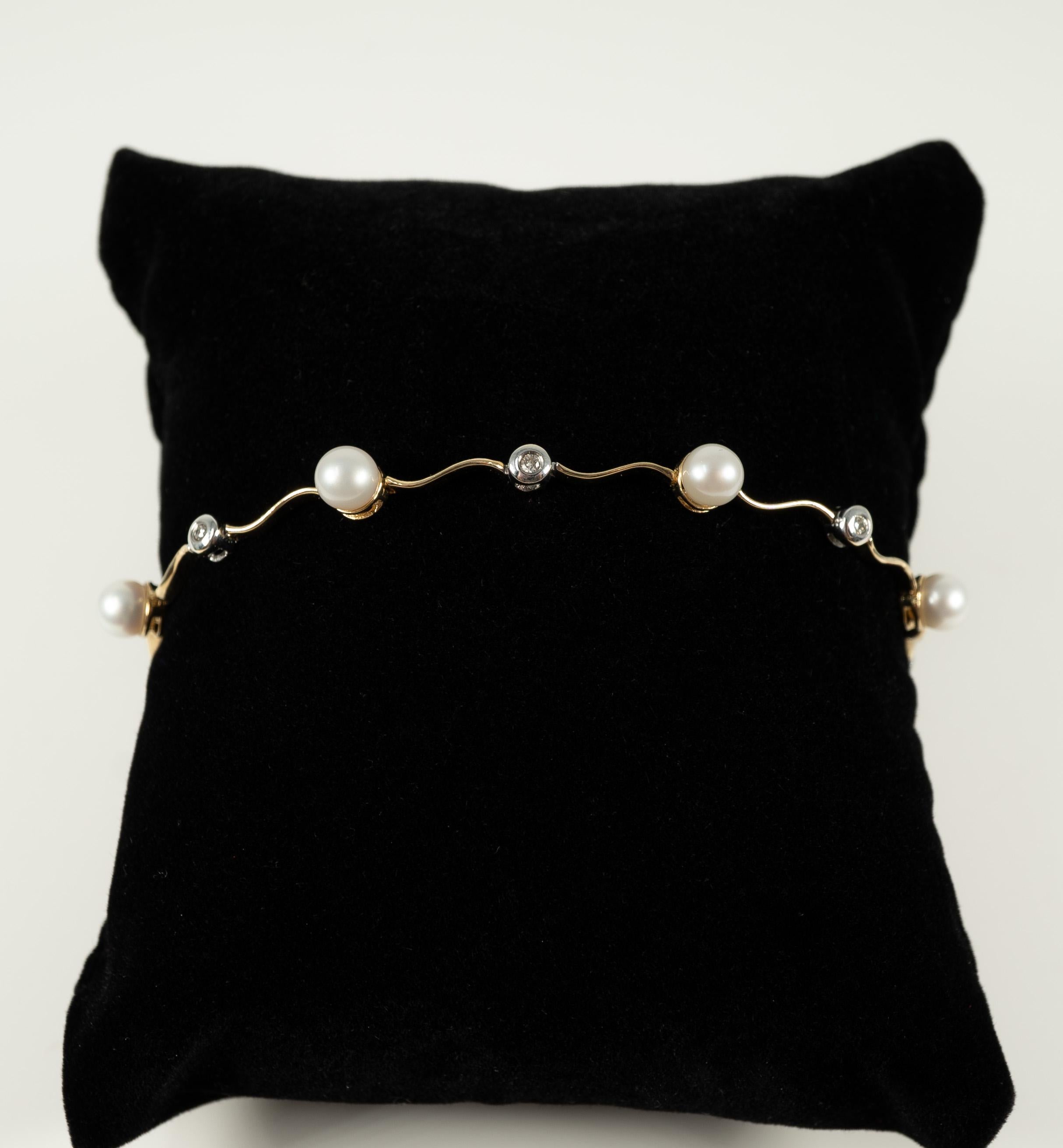 In 14 karat yellow and white gold, this lovely bracelet supports six round cultured pearls, measuring approximately 4.00 mm each, with accent diamonds