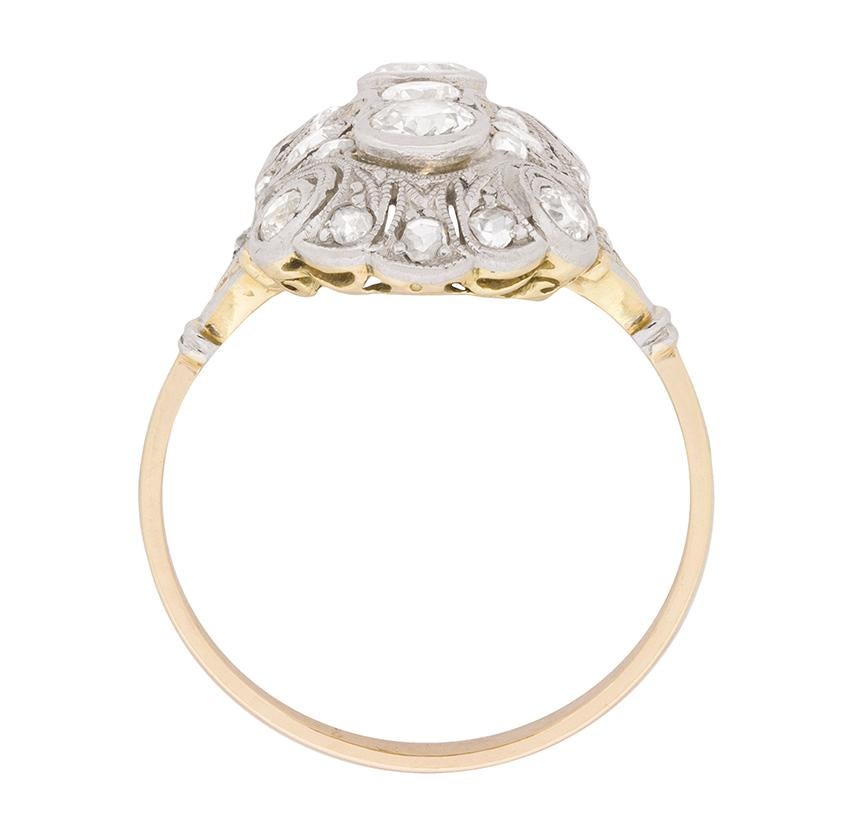A captivating quintet of old cut diamonds forms the heart of this gorgeous Edwardian era dinner ring.

One further diamond punctuates each corner of the ring’s rectangular, openwork, platinum mounting, which is sumptuously decorated with rose cut