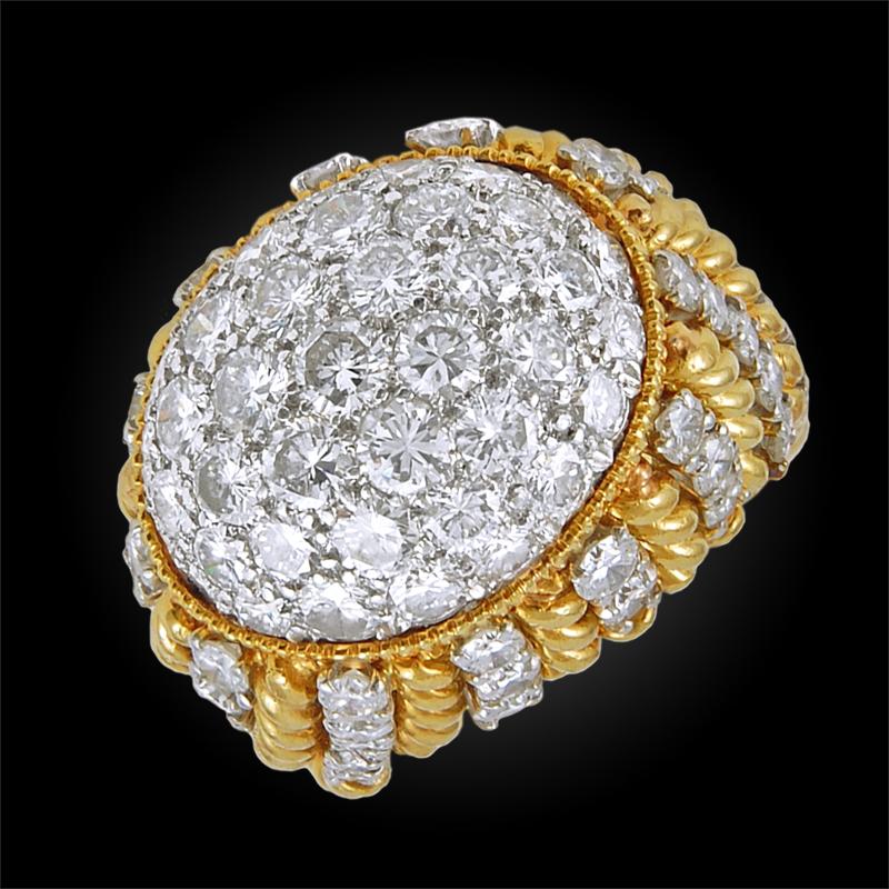 A resplendent ring of dome shape design, crafted with alternating rows of textured 18k yellow gold and brilliant diamonds mounted in platinum, centering a pavé of round brilliant cut diamonds. Ring size 6.
Circa 1960s