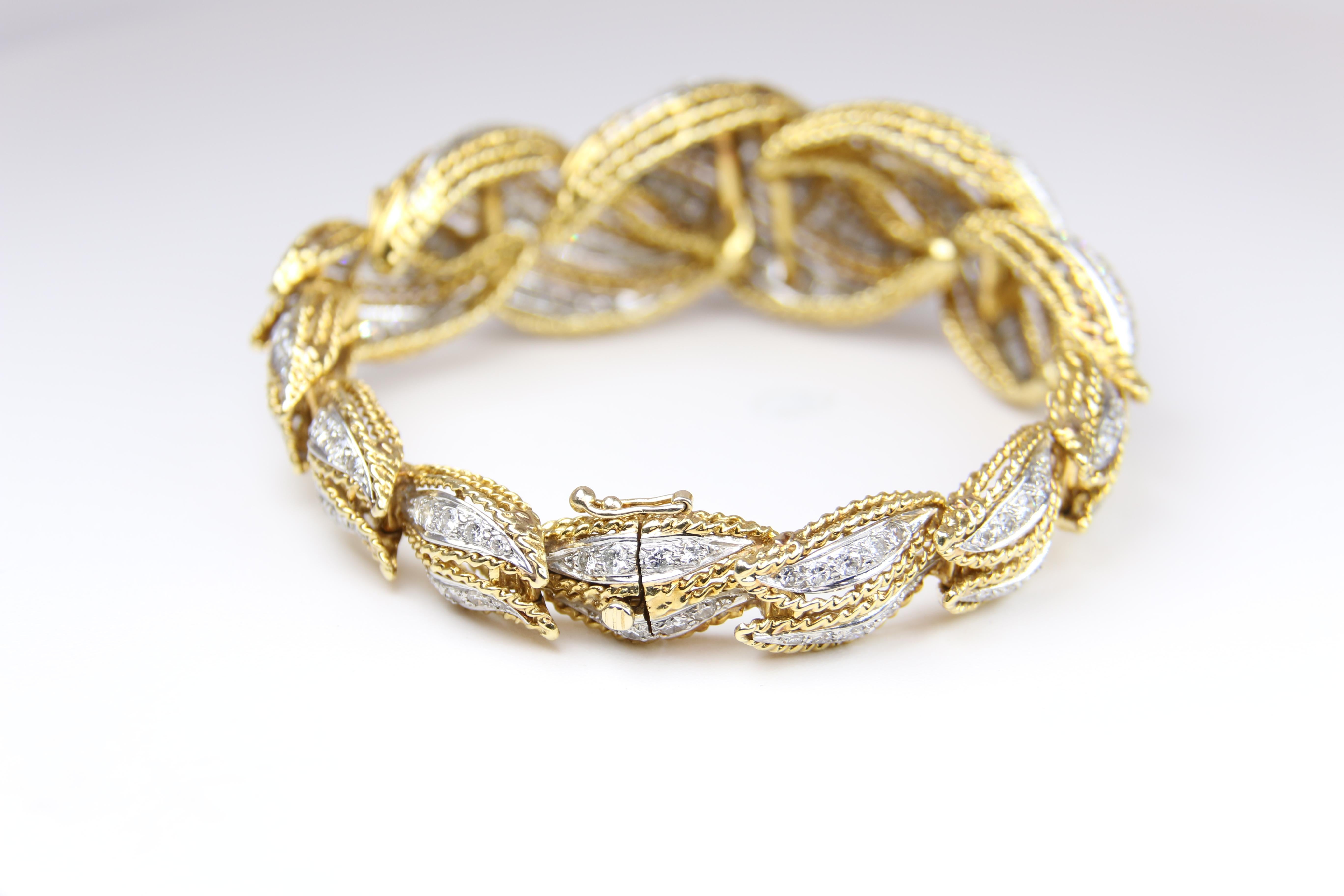 18K two toned diamond scrolled bracelet.  Diameter 6.5 inches  Hidden Clasp.  Scrolls get larger in the middle of the bracelet with width at the largest portion of the bracelet of 1 inch.  
