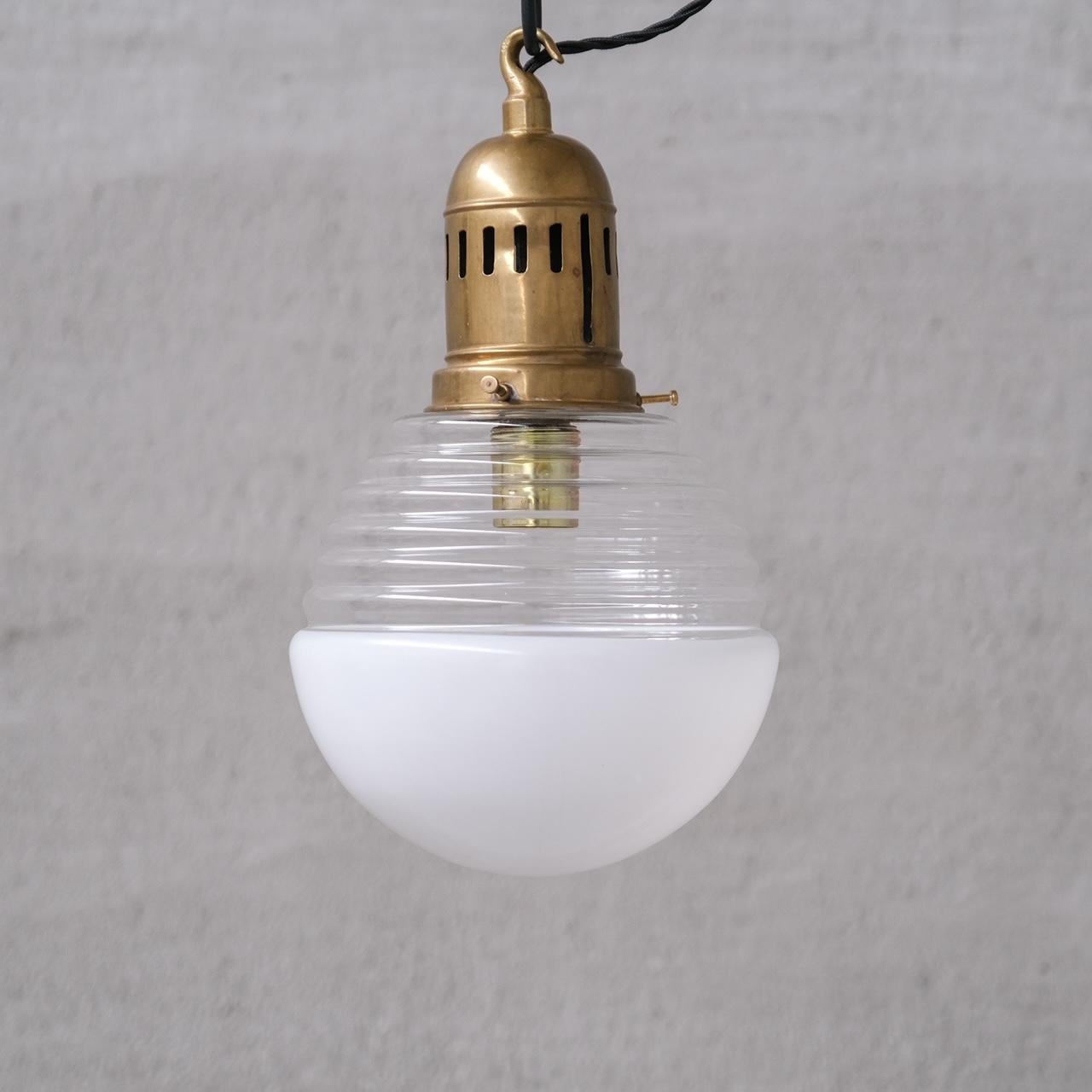 A single two tone glass and brass pendant light, 

France, c1950s. 

Opaline glass base, clear top, original brass gallery.

No rose was retained or chain, however they are easy to source online. 

Good vintage condtion, re-wired and PAT