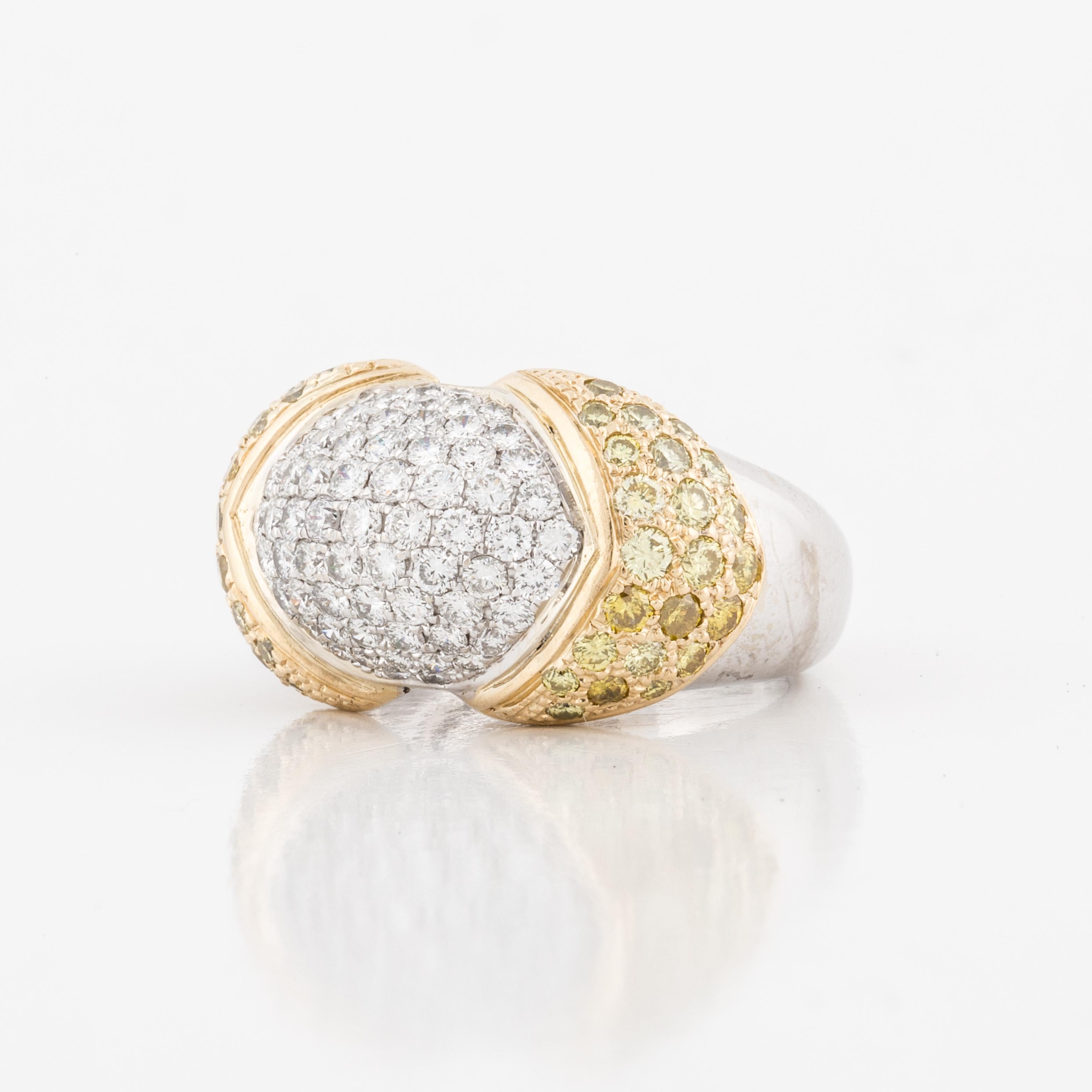 Pavé diamond domed ring in 18K yellow and white gold.  The center is a small dome with sixty-five round diamonds that total 1.20 carats; F-G color and VS clarity.  On the sides of the domed center there are forty-six round yellow diamonds; Fancy