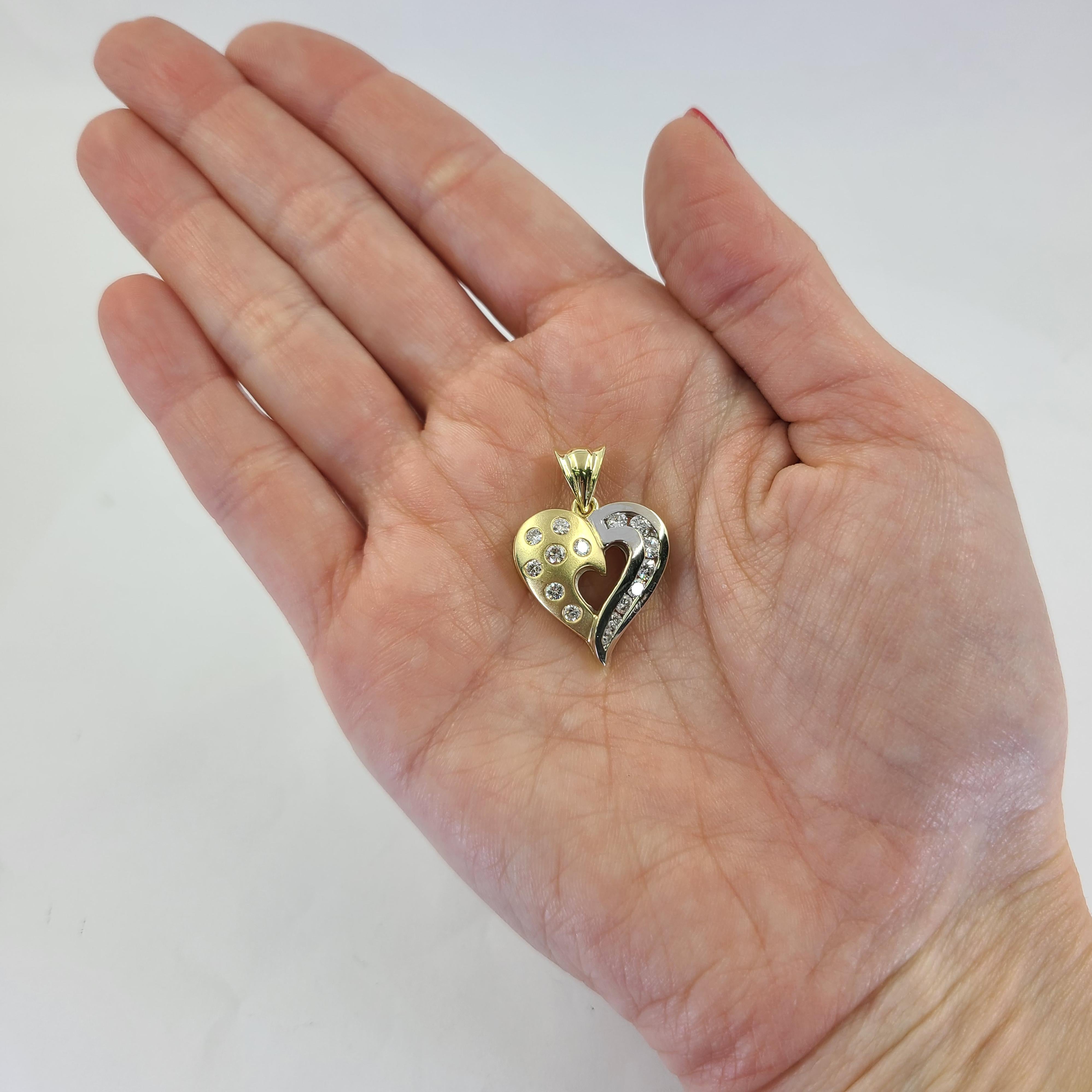 18 Karat White and Yellow Gold Matte Finish Heart Pendant Featuring 15 Channel and Flush Set Round Brilliant Cut Diamonds of VS Clarity and G/H Color. 1 Inch Length. Finished Weight Is 8.5 Grams.